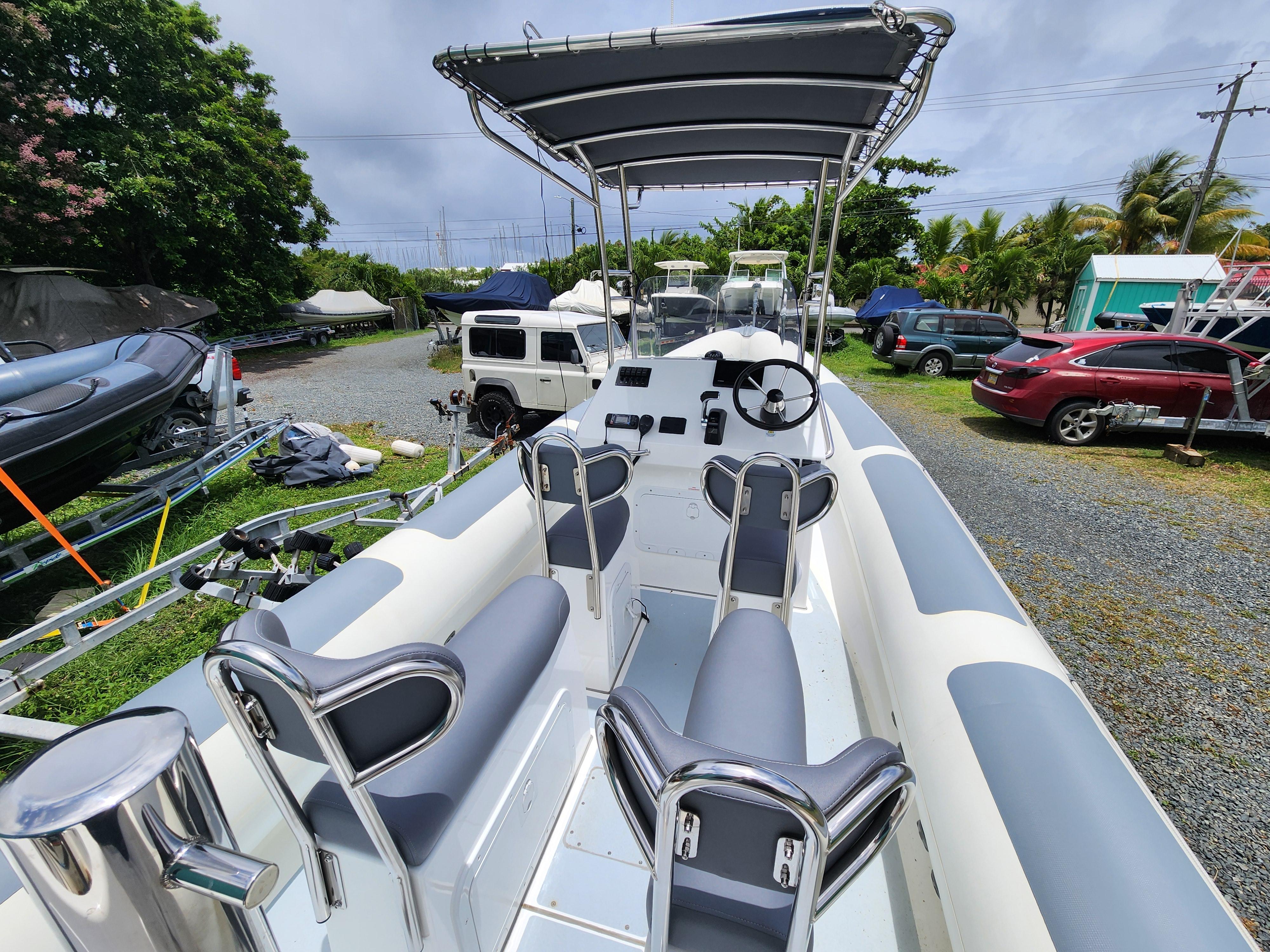 2023 Island RIBs 7.5 m boat with seating and canopy in a parking area.