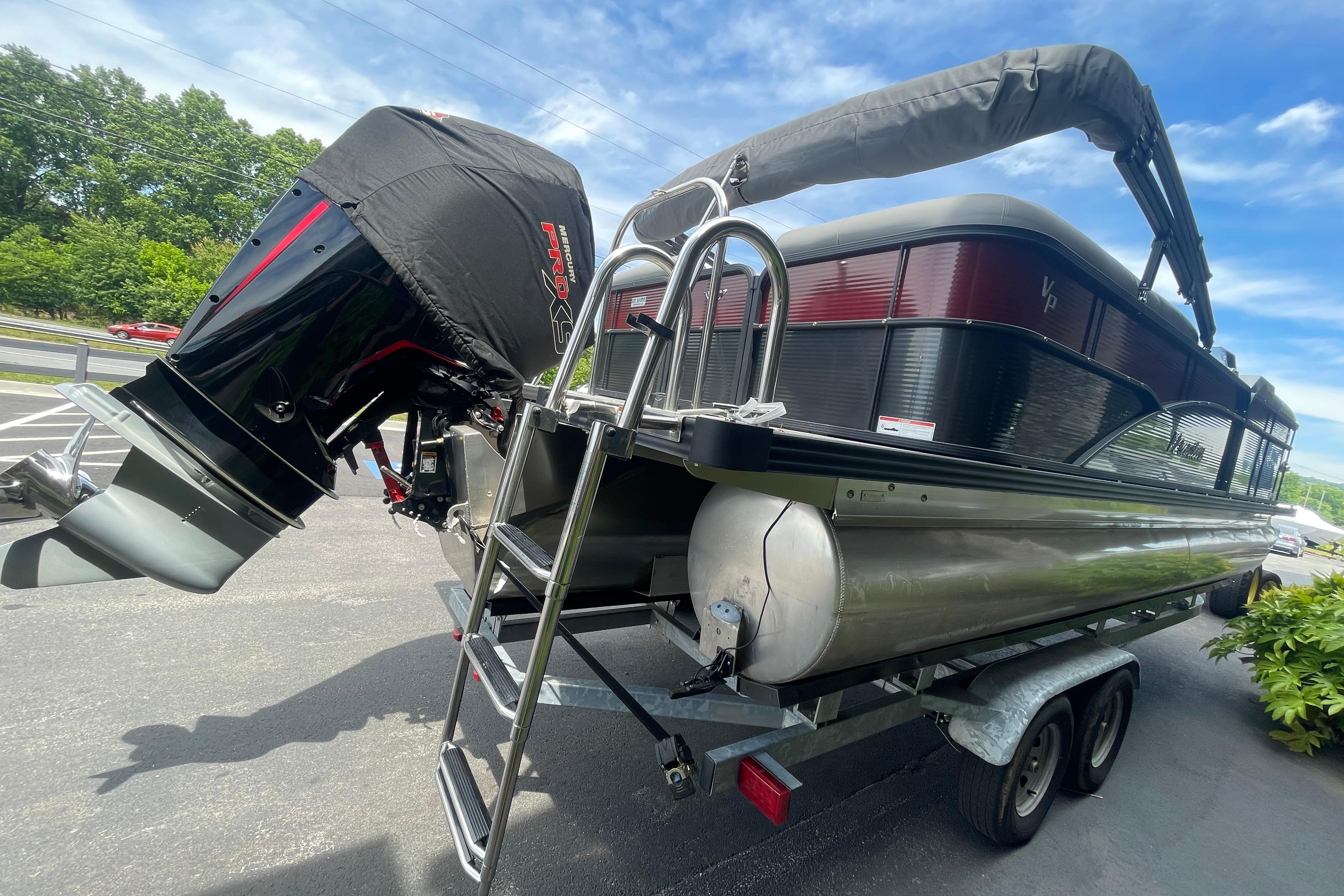 2022 Manitou 23 Oasis pontoon boat on trailer with powerful outboard motor.