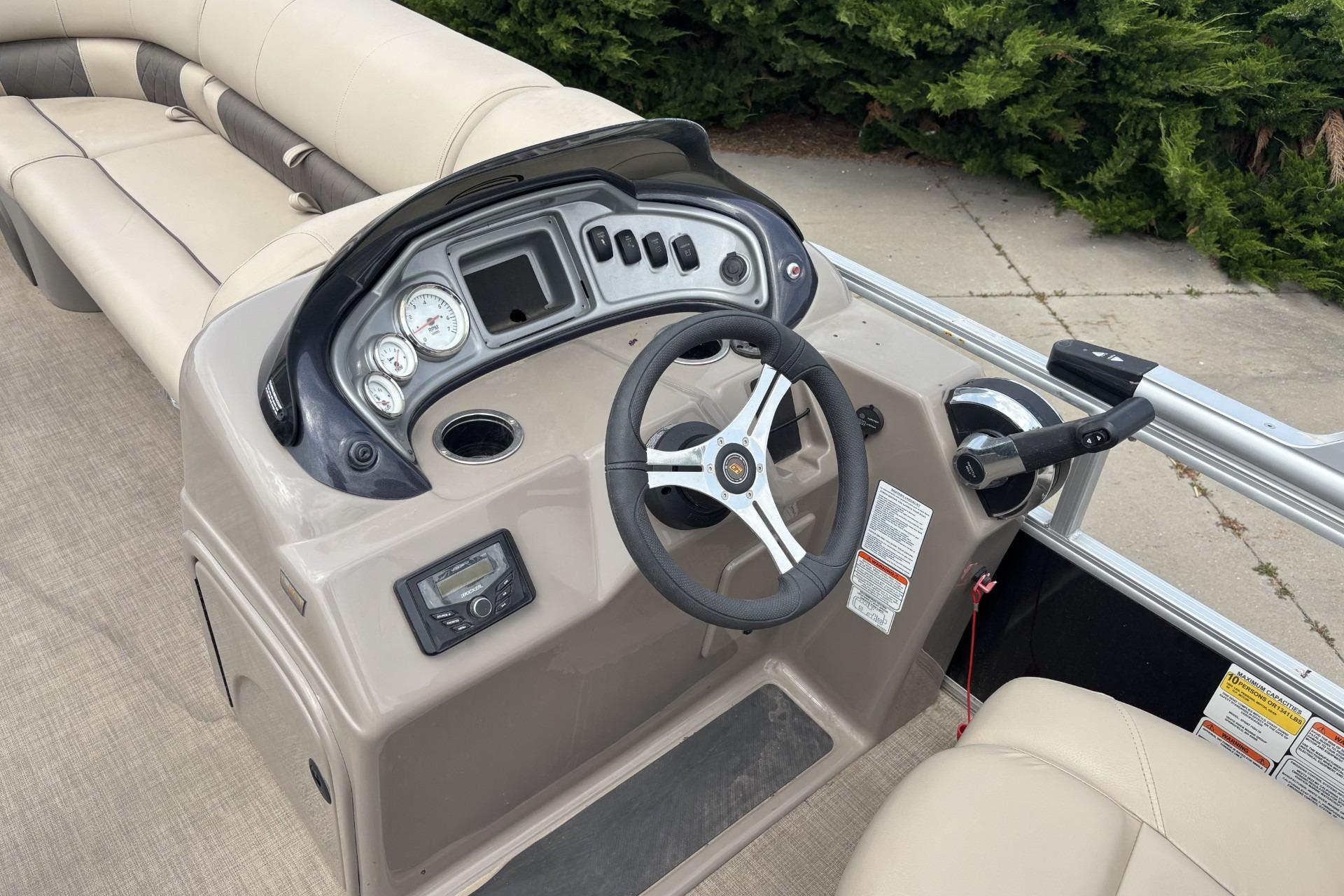 2023 Sun Tracker SportFish 20 DLX boat dashboard with steering wheel and controls.