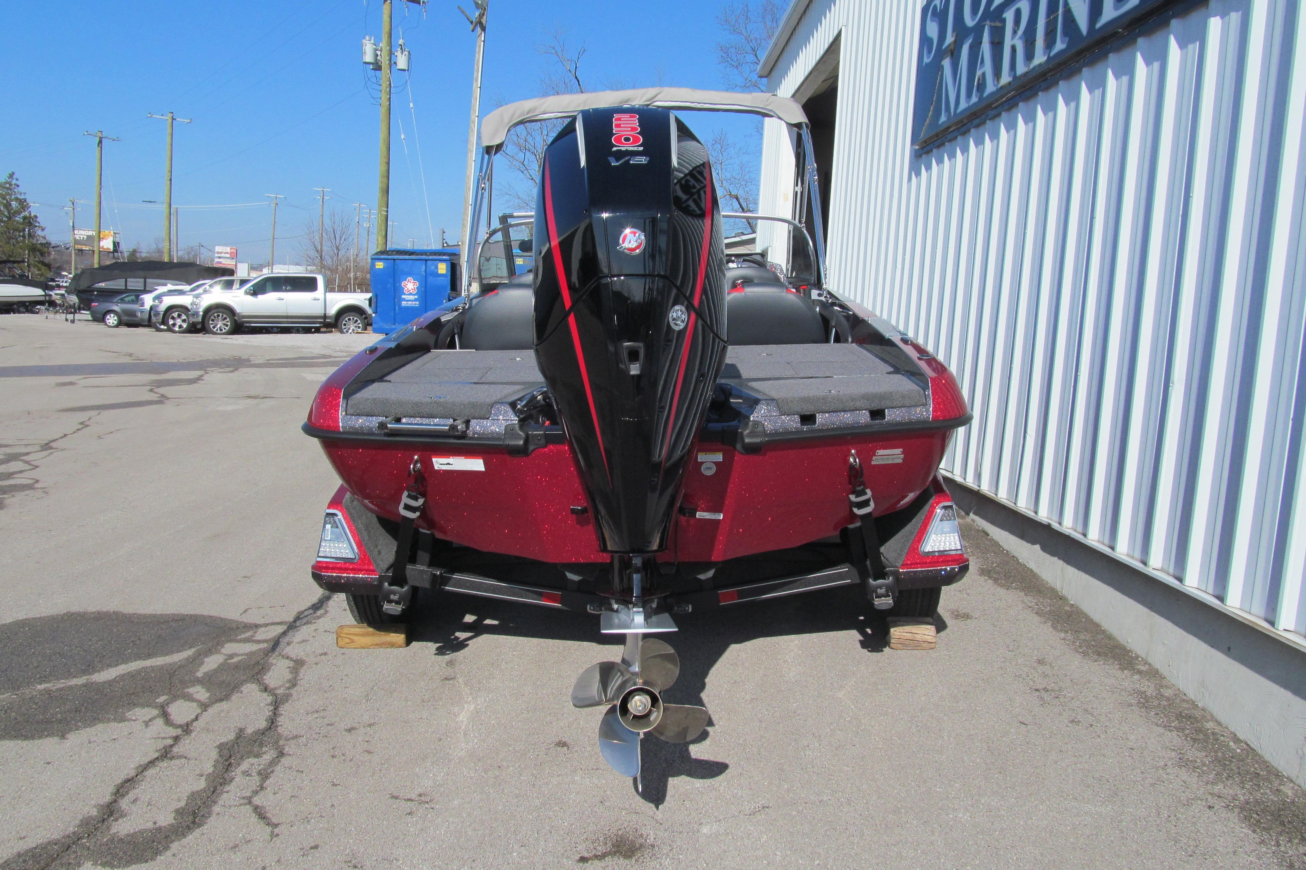 2026 Ranger 212LS boat with powerful outboard motor, parked outside a marine store.