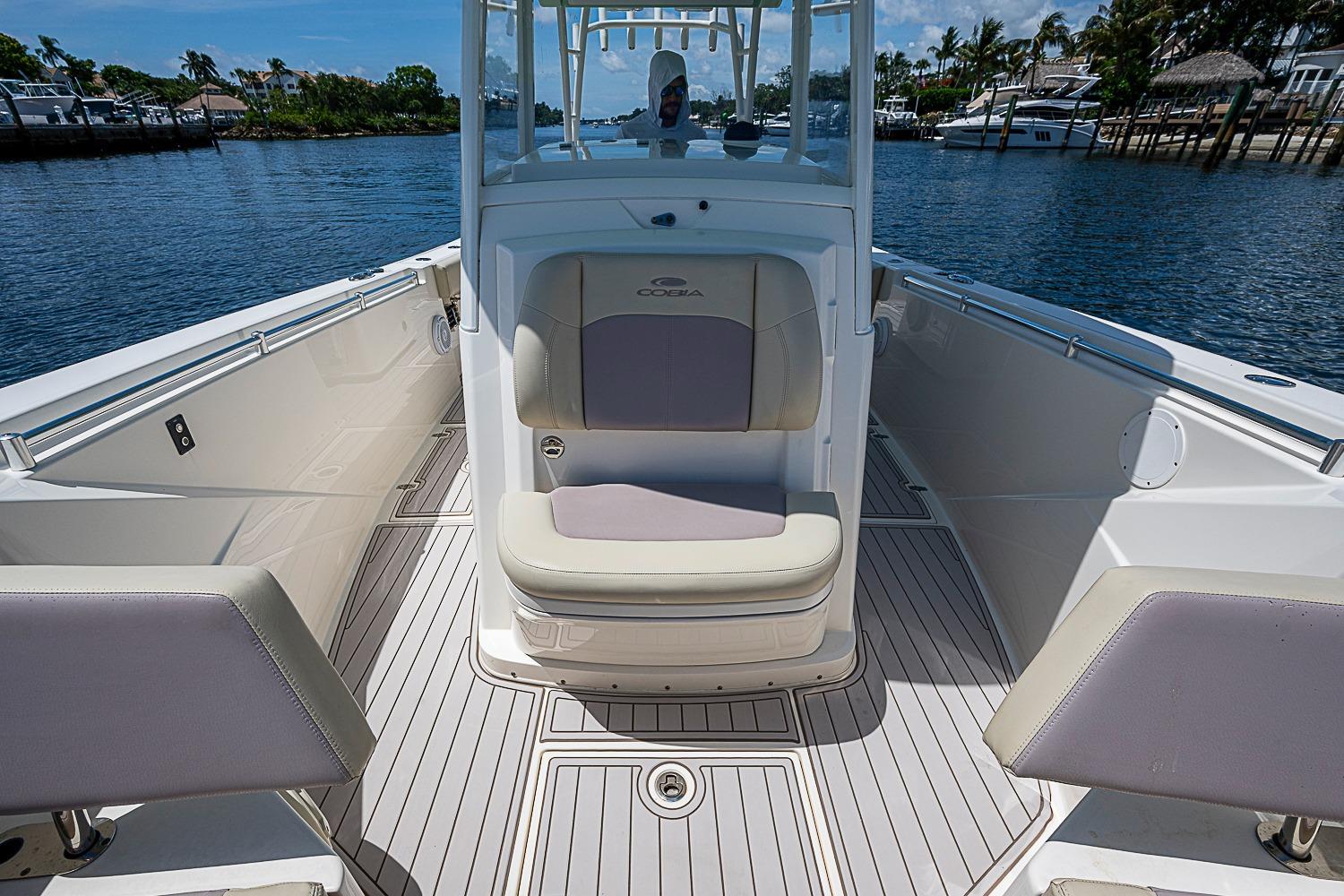 2019 Cobia 320 Center Console boat interior with seating, on a calm waterway.