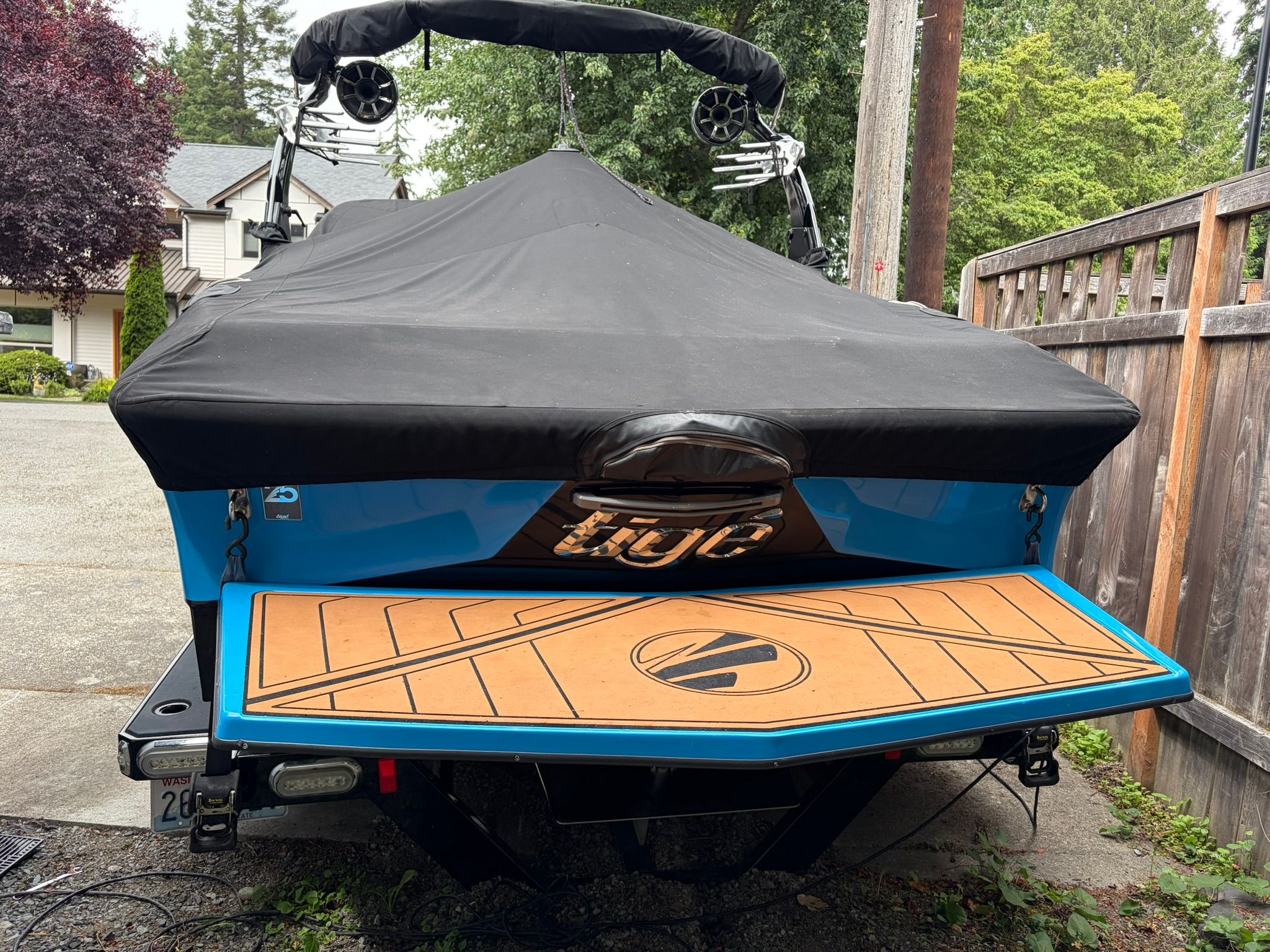 The image shows a blue 2016 Tigé RZ2 boat with a black cover.