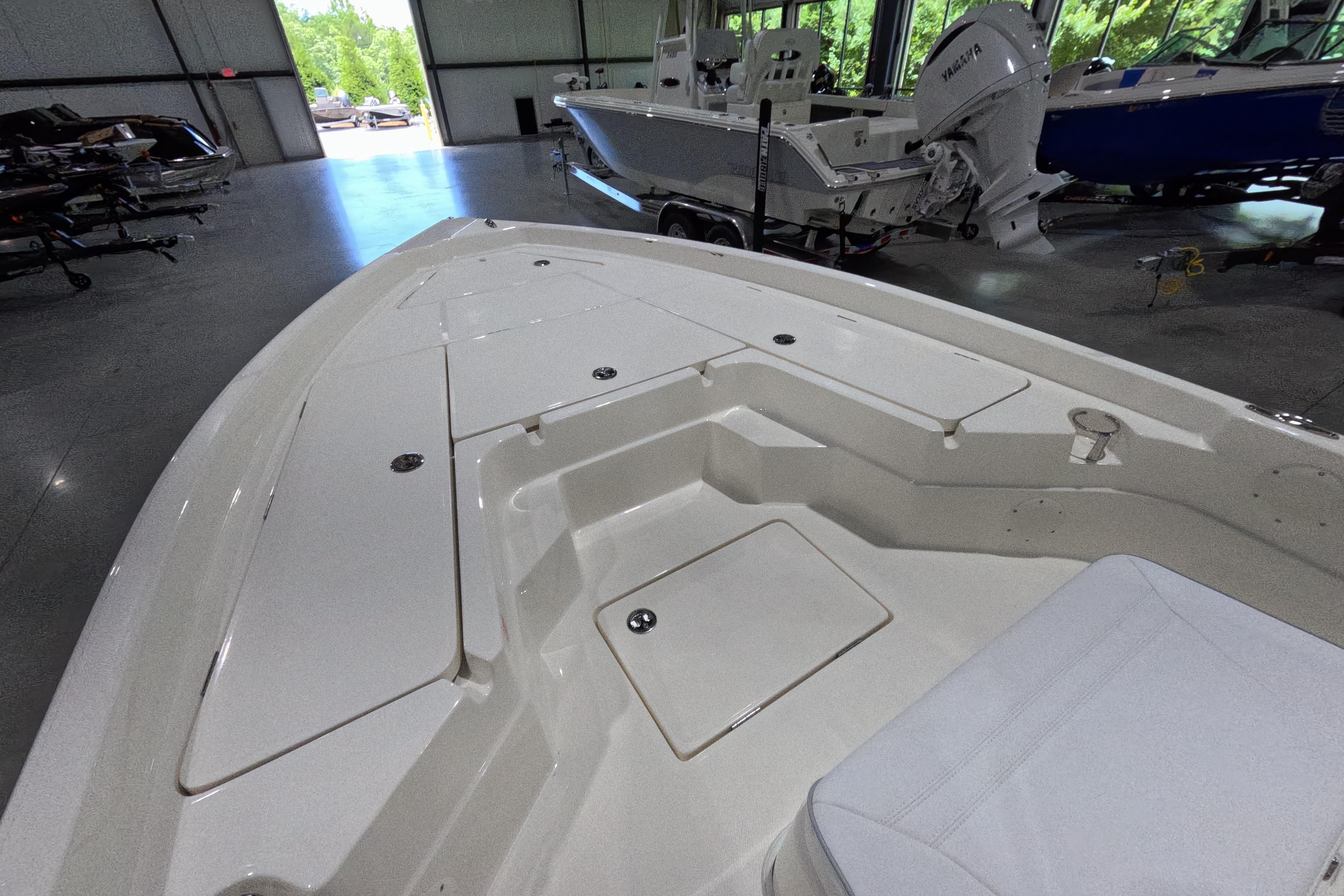 2026 Skeeter SX230 boat interior with storage compartments in a showroom.