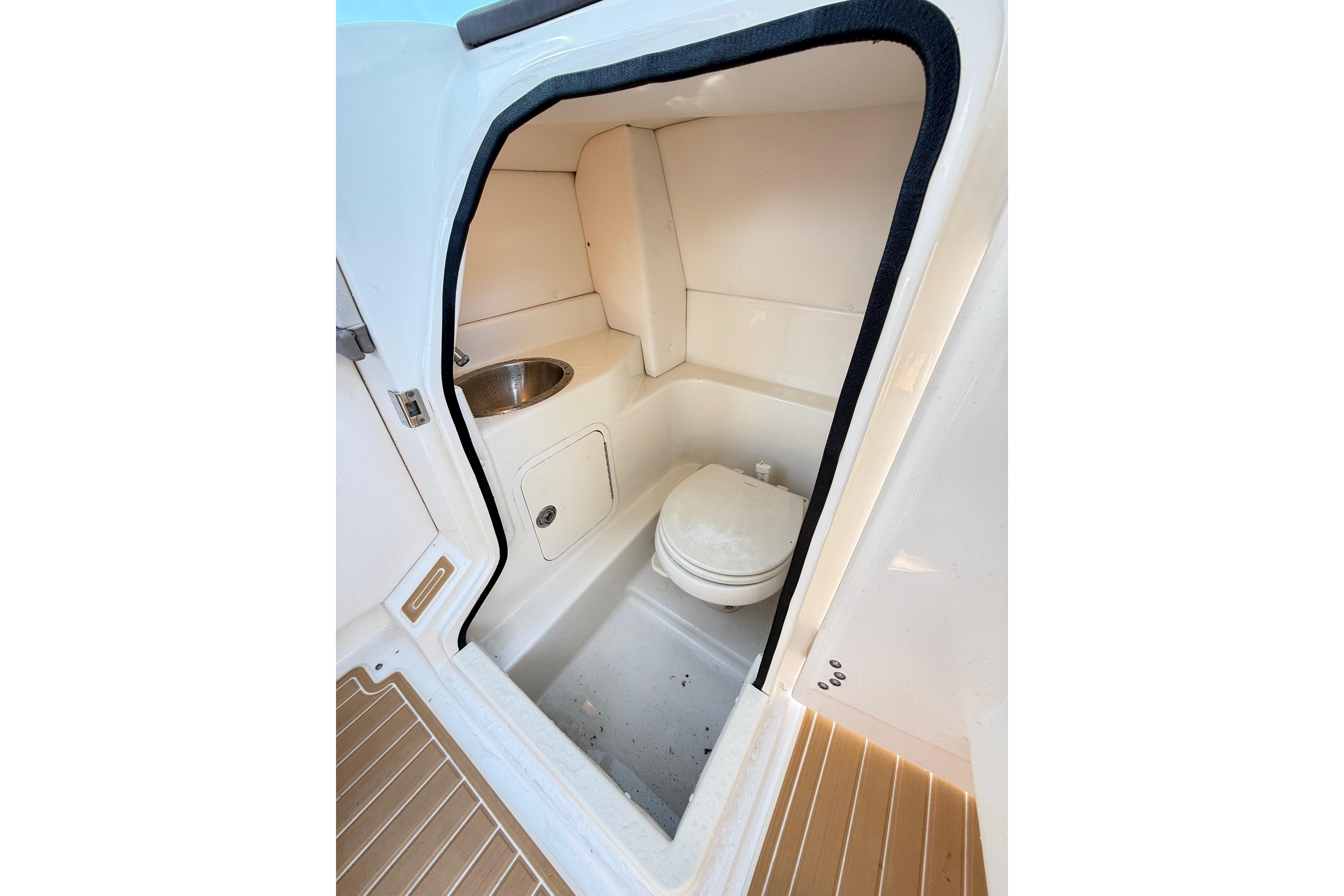 Interior of 2011 Sea Ray 270 SLX boat bathroom with toilet and sink.