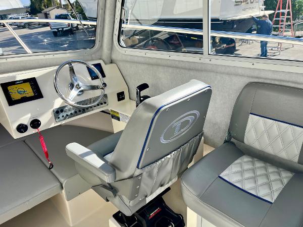 2023 Defiance Admiral 220 EX boat interior with steering wheel and seating.