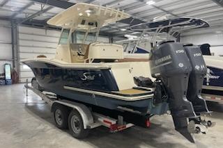 2015 Scout 255 LXF boat with dual Yamaha engines on a trailer in a warehouse.