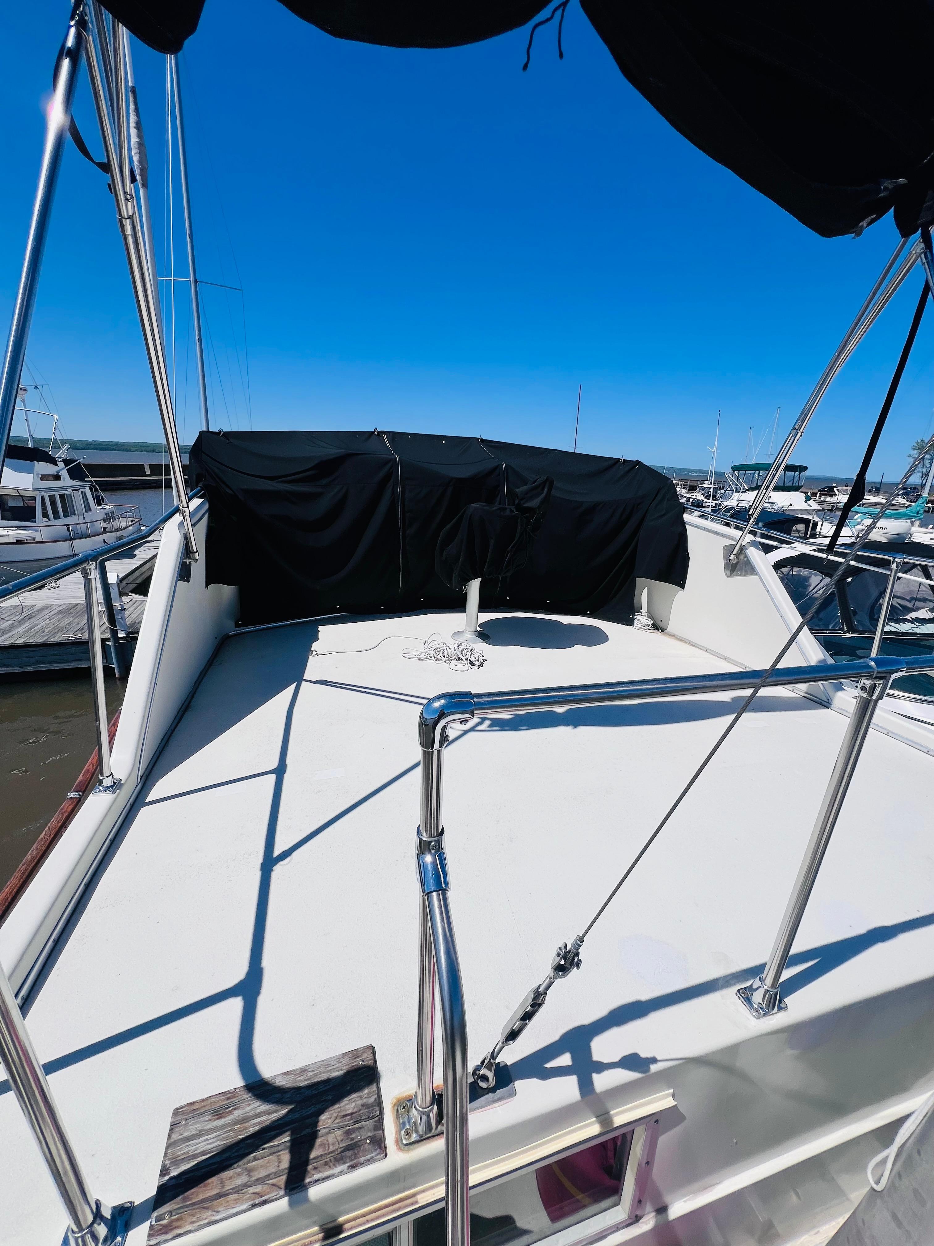 1974 Tollycraft 40 Tri-Cabin Motoryacht deck view at marina under clear blue sky.