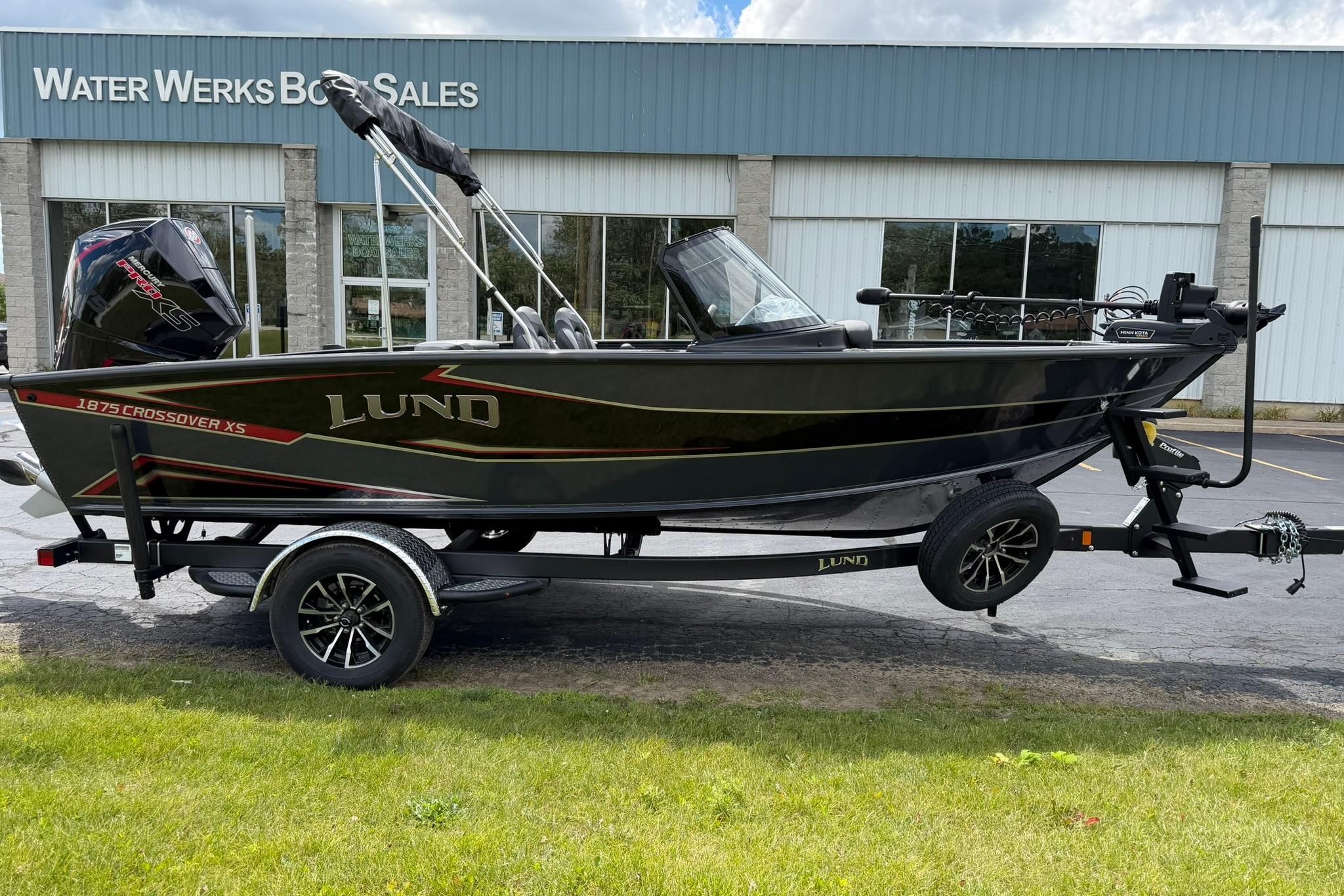 2027 Lund 1875 Crossover XS boat on trailer at dealership.