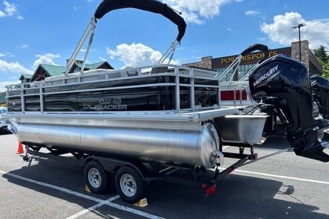 2026 Sun Tracker Fishin' Barge 20 DLX pontoon boat on trailer, parked outdoors.