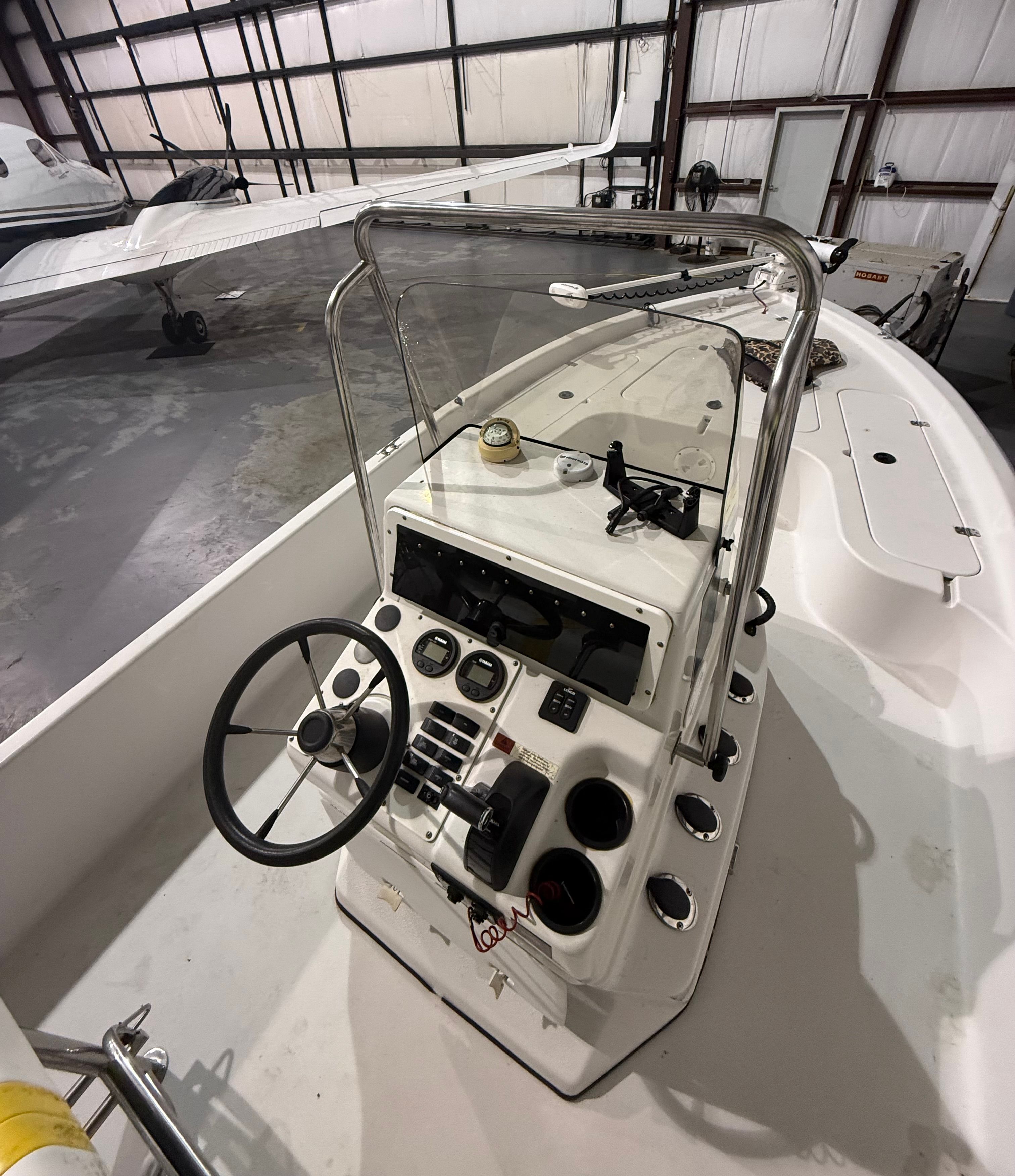 The image shows the helm of a 2004 Champion 24 Bay Champ boat in a storage facility.