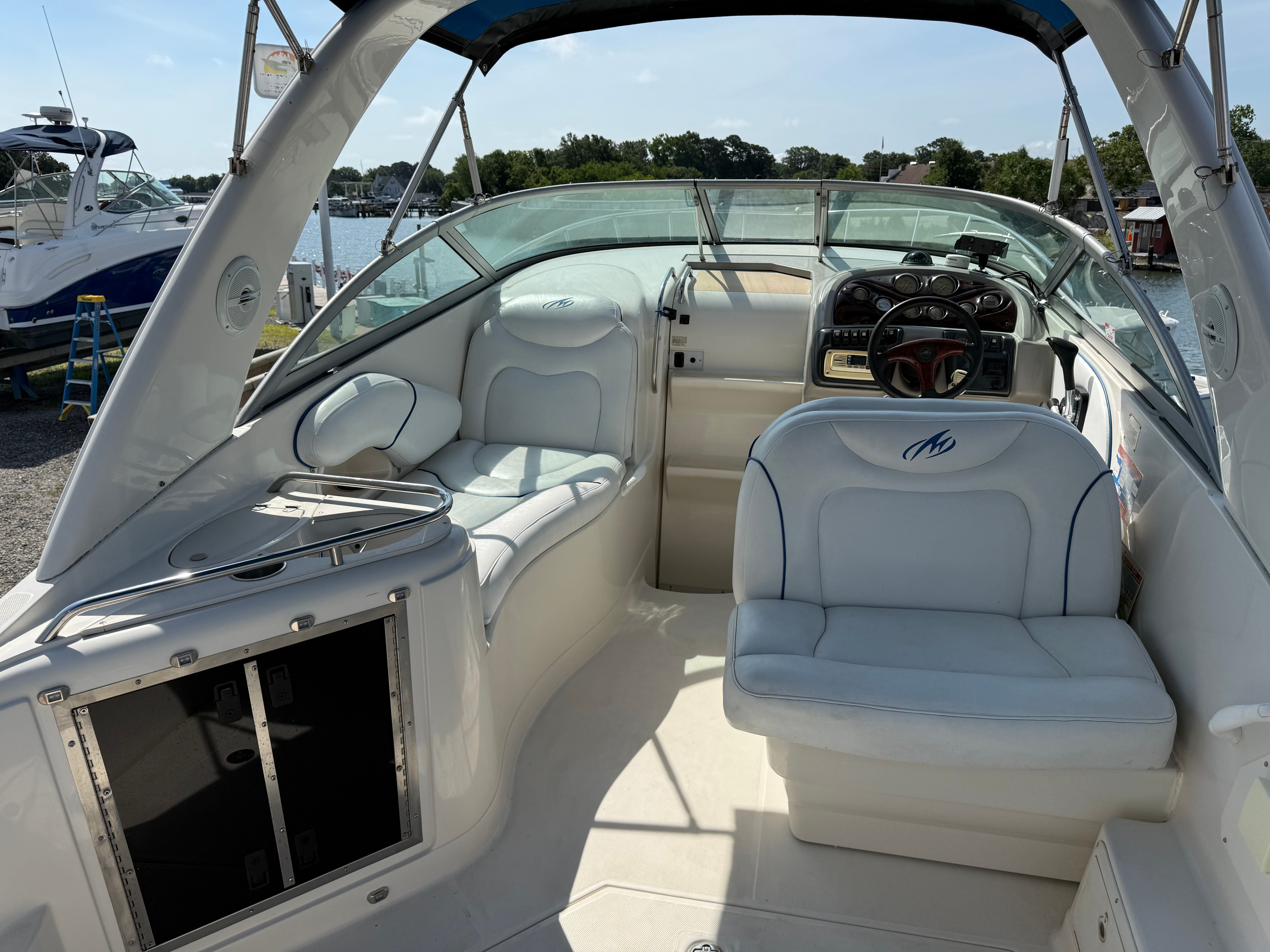 The image shows the cockpit of a 2006 Monterey 270 Cruiser with white seating and a steering wheel.