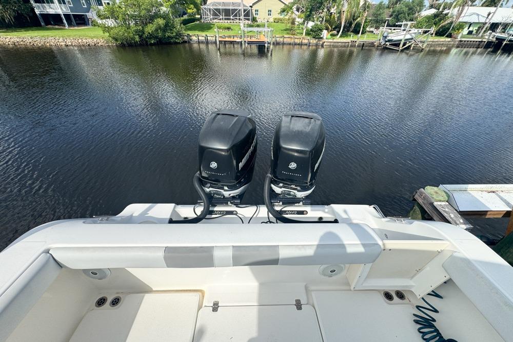 2018 Mako 284 Center Console boat with dual outboard motors on a calm river.