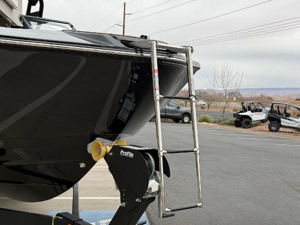2025 Yamaha Boats 255XD with ladder on trailer in parking lot.