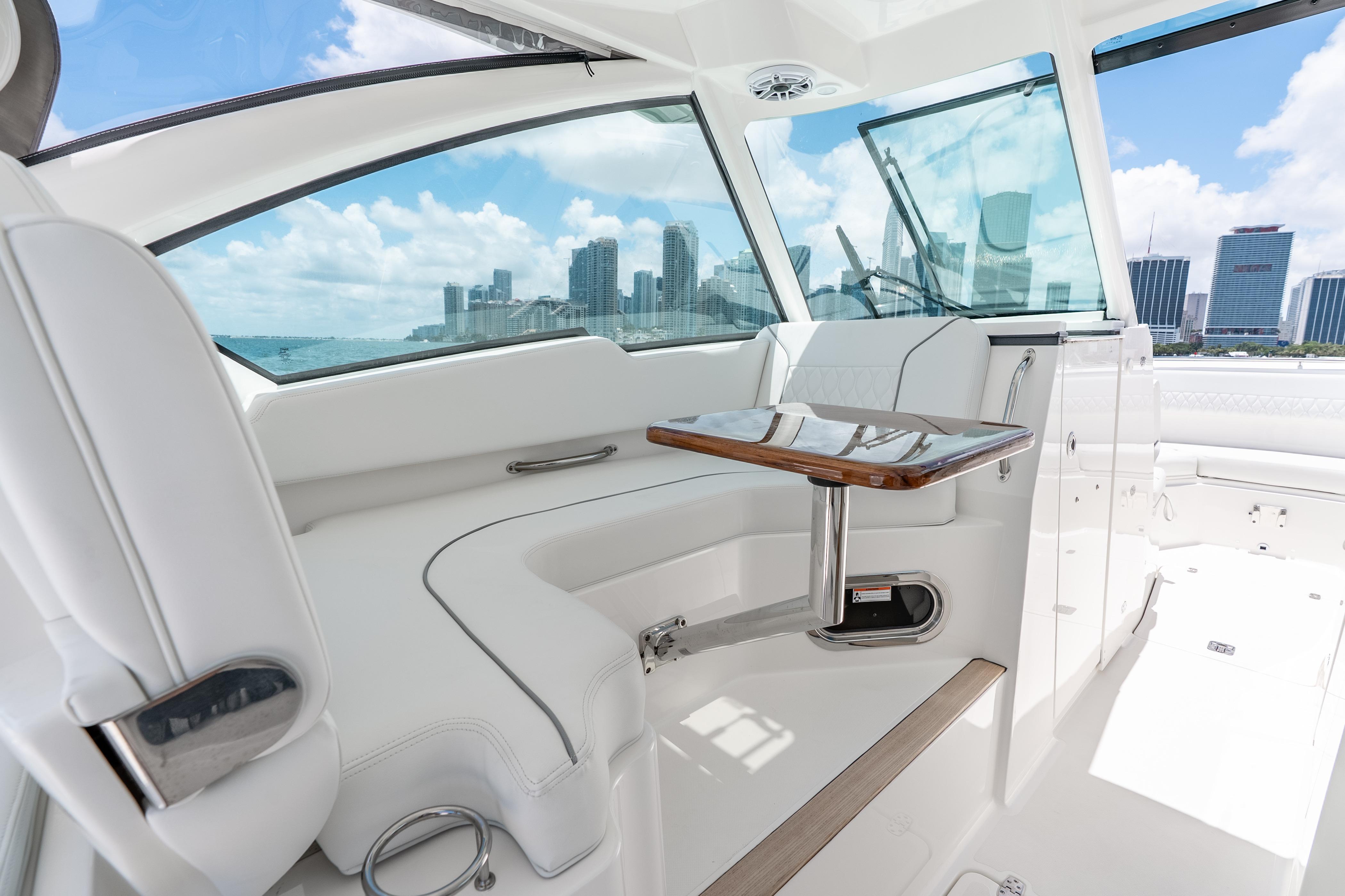 Luxurious interior of 2026 Pursuit DC 326 Dual Console boat with city skyline view.