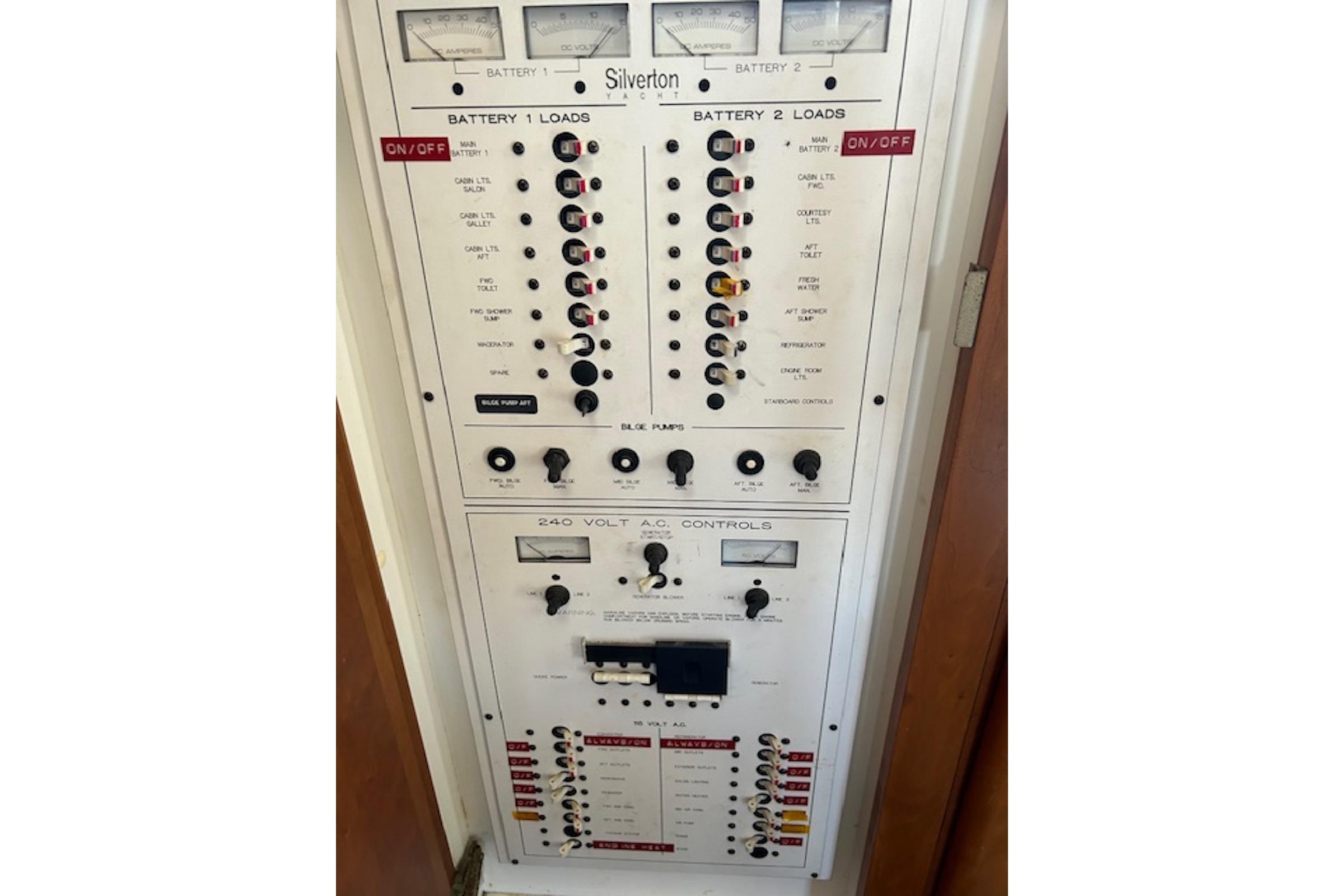 Electrical control panel of a 1996 Silverton 442 Cockpit Motor Yacht, featuring battery and AC controls.