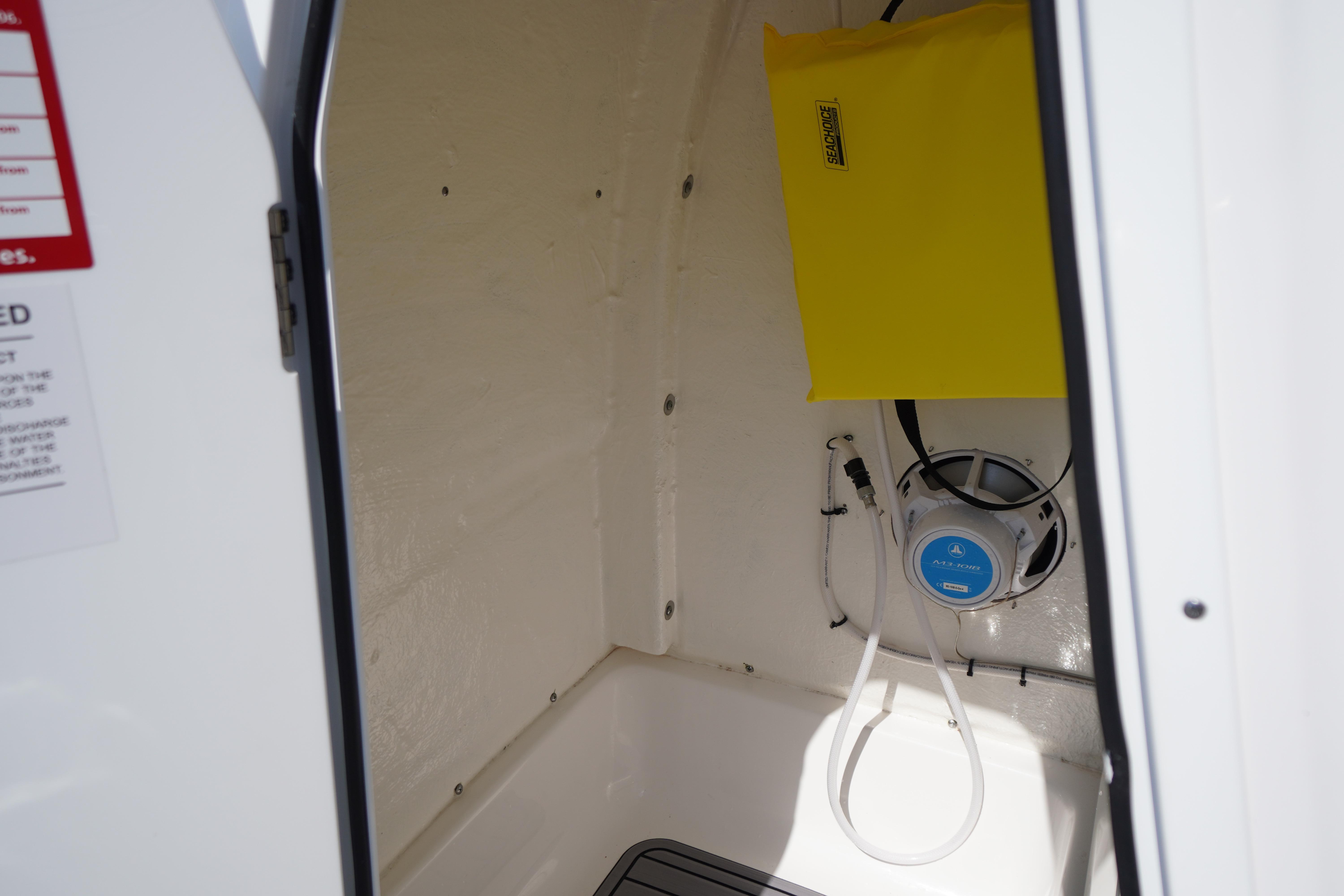 Interior of 2025 Tidewater 232 SS boat, featuring storage compartment and marine speaker.