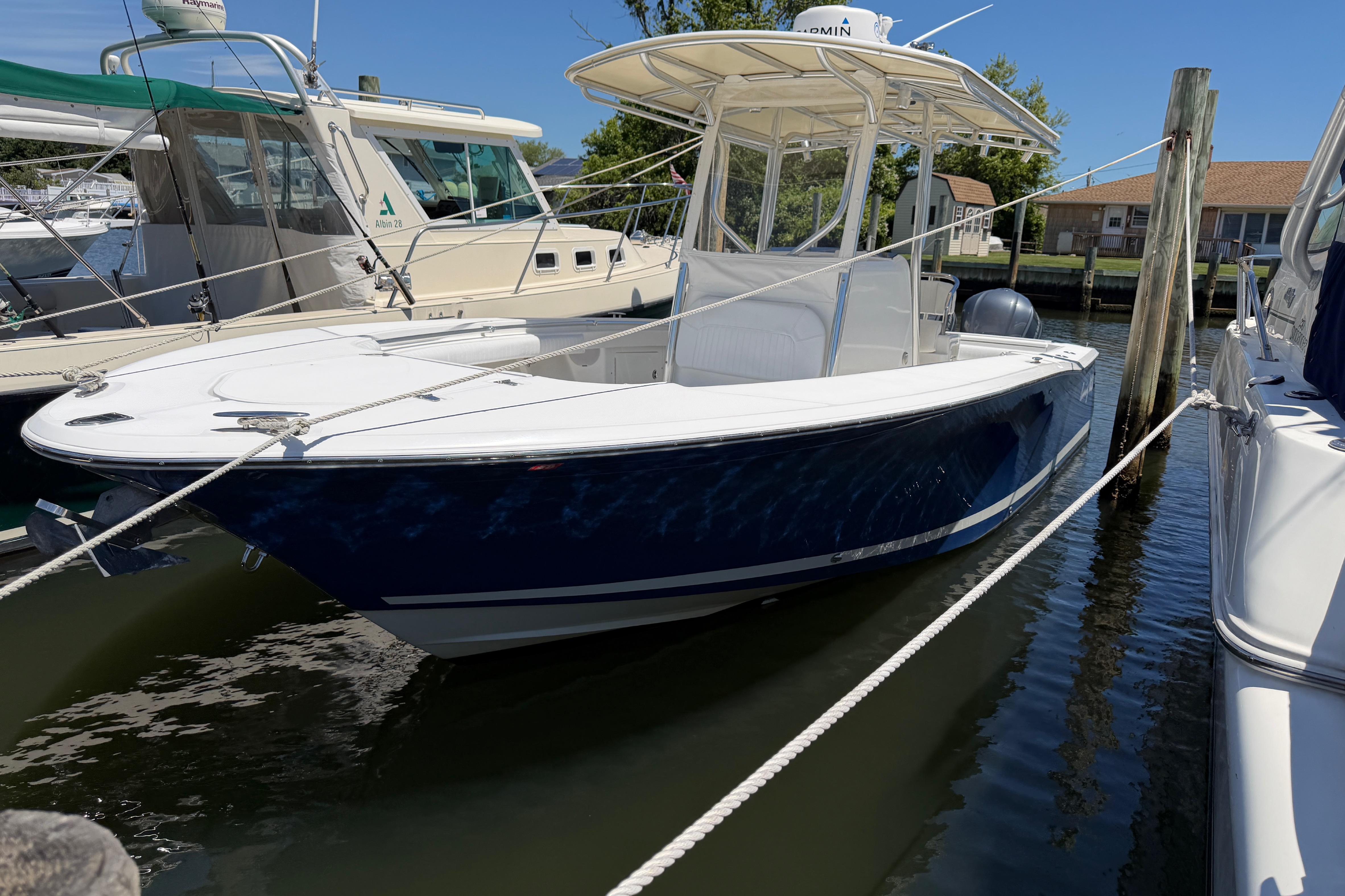 2006 Southport 26 Center Console boat docked in marina, blue hull, white deck.