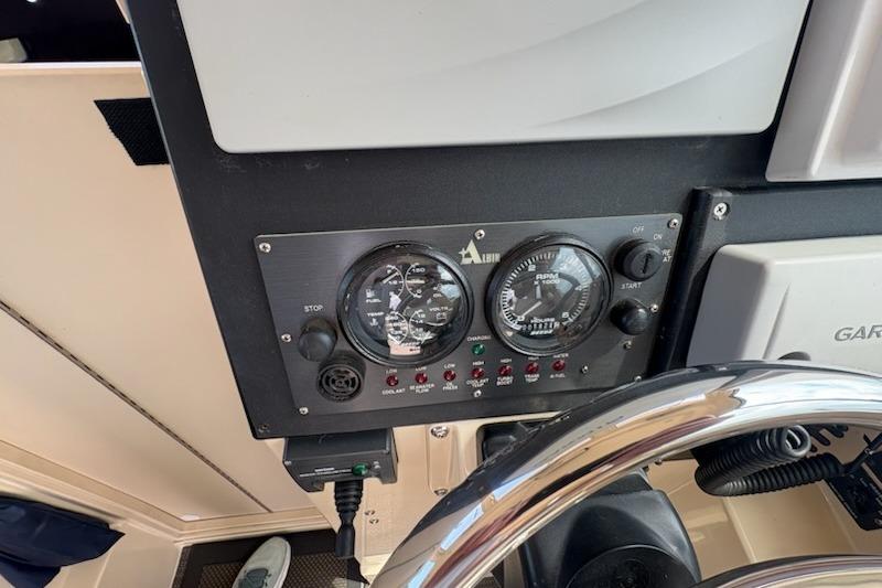 Control panel of a 2003 Albin 28 Tournament Express boat with gauges and switches.