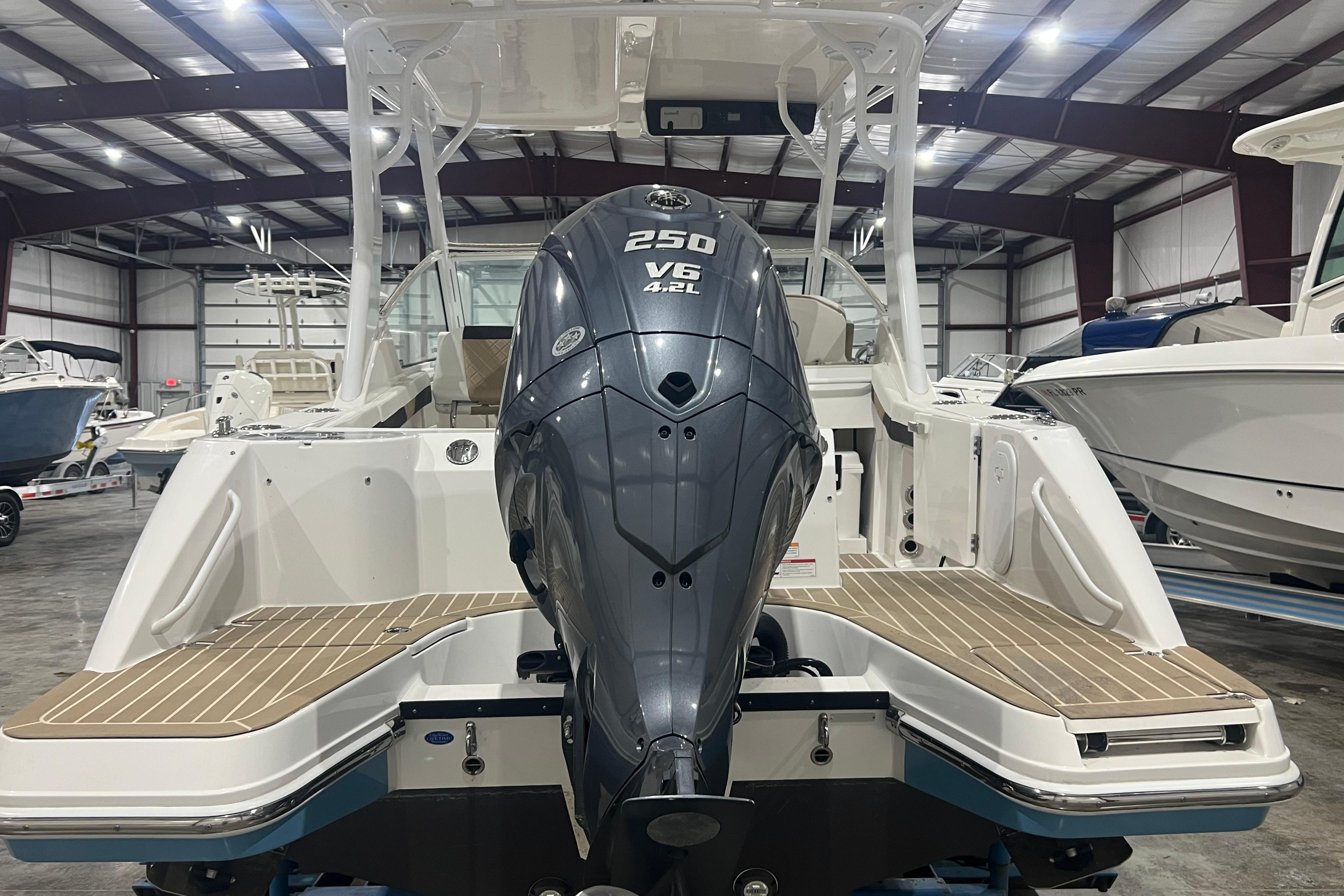 2023 Edgewater 230CX Crossover boat with powerful V6 engine in showroom.