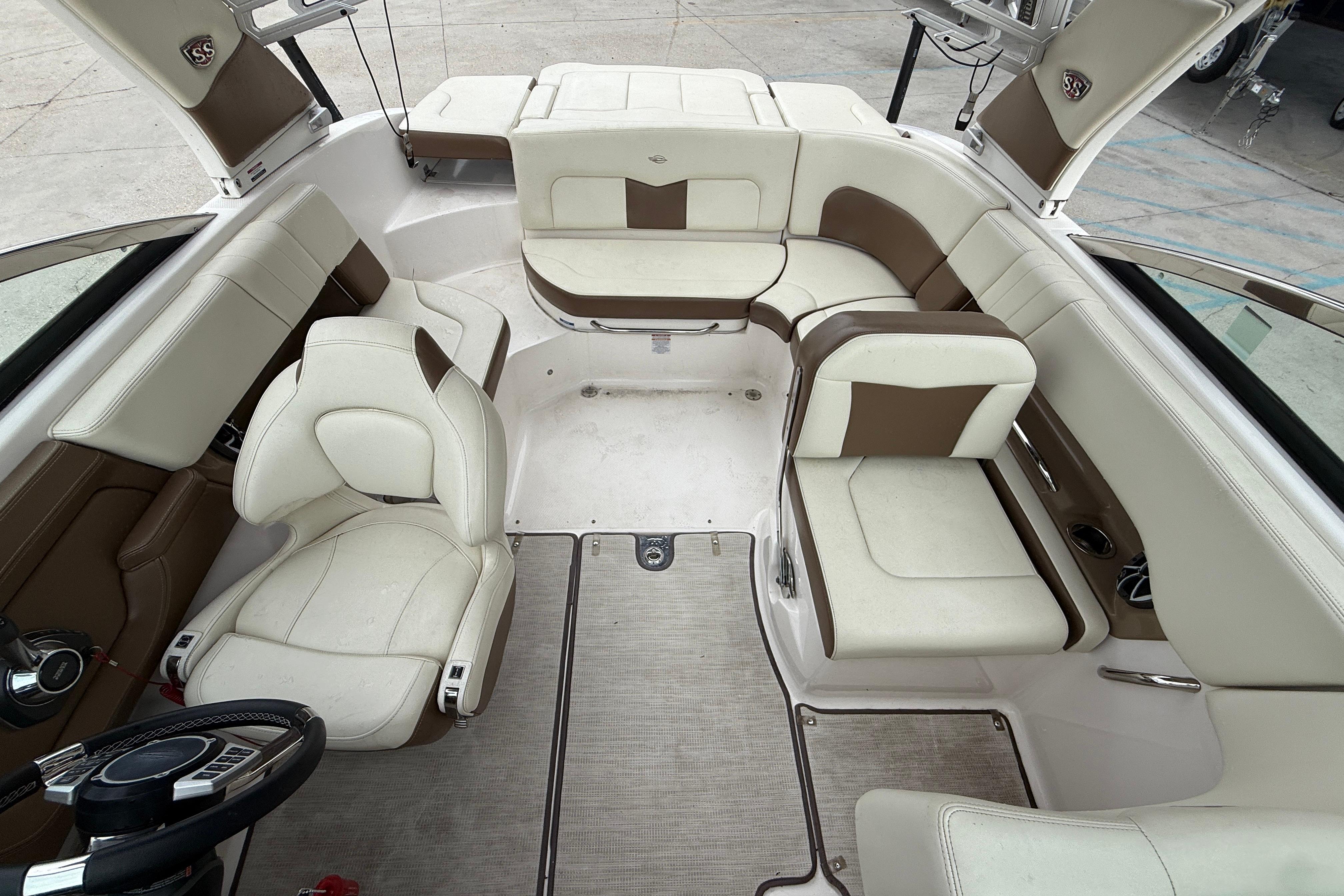 2018 Chaparral 227 SSX Surf boat interior with white and brown seating.