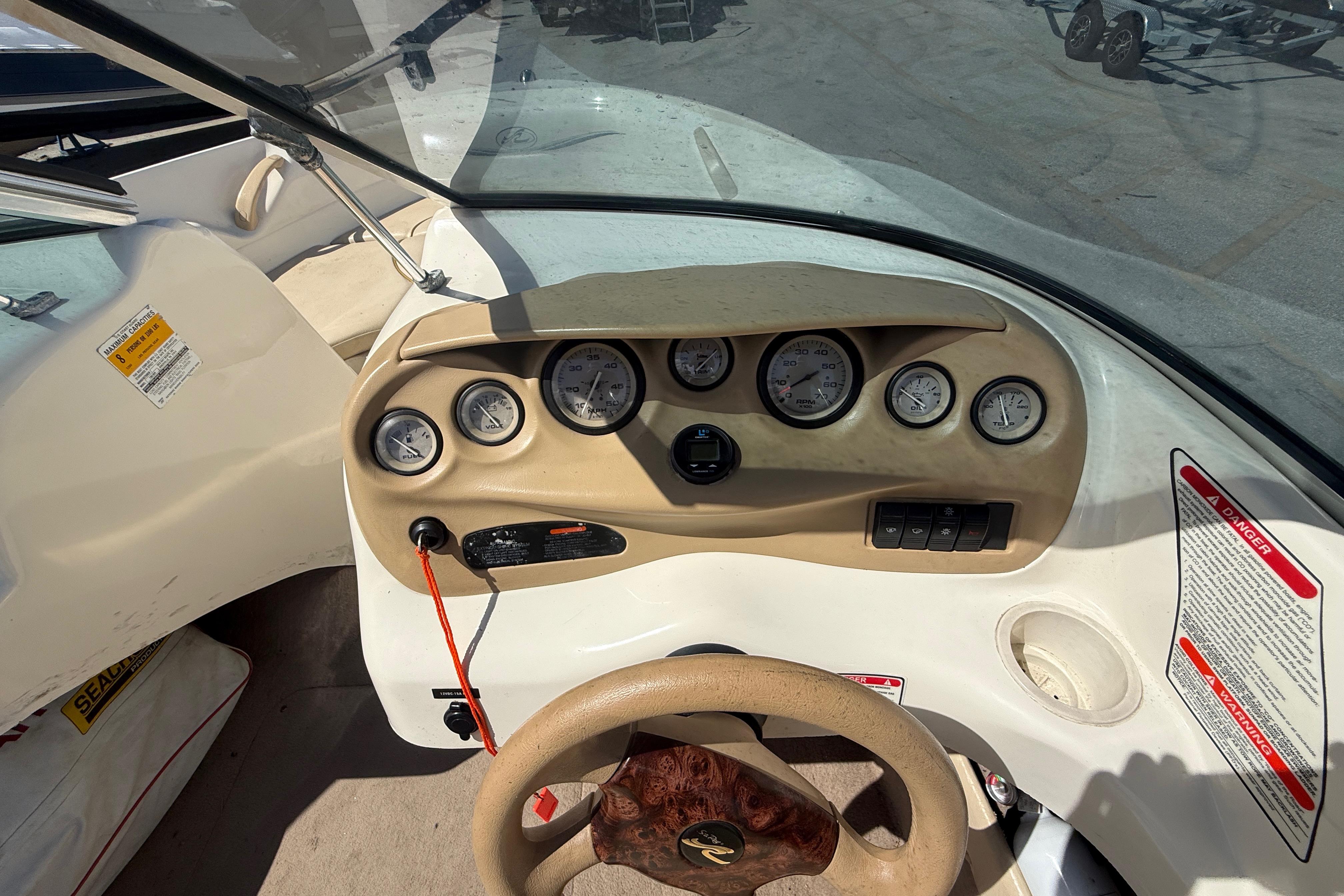 Dashboard of a 2001 Sea Ray 180 Bow Rider boat with gauges and steering wheel.