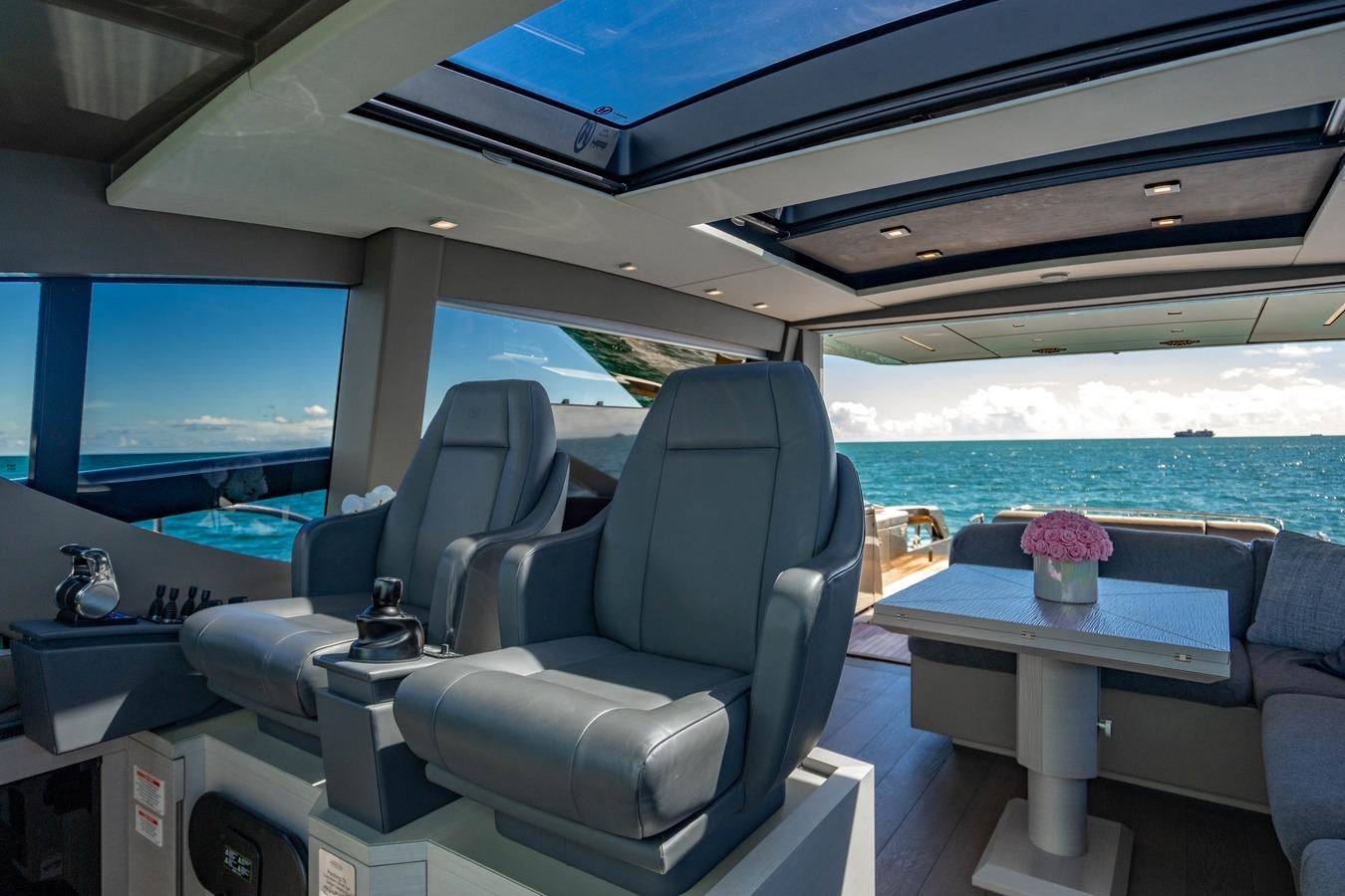 Luxurious interior of 2023 Pershing 7X yacht with ocean view and modern seating.