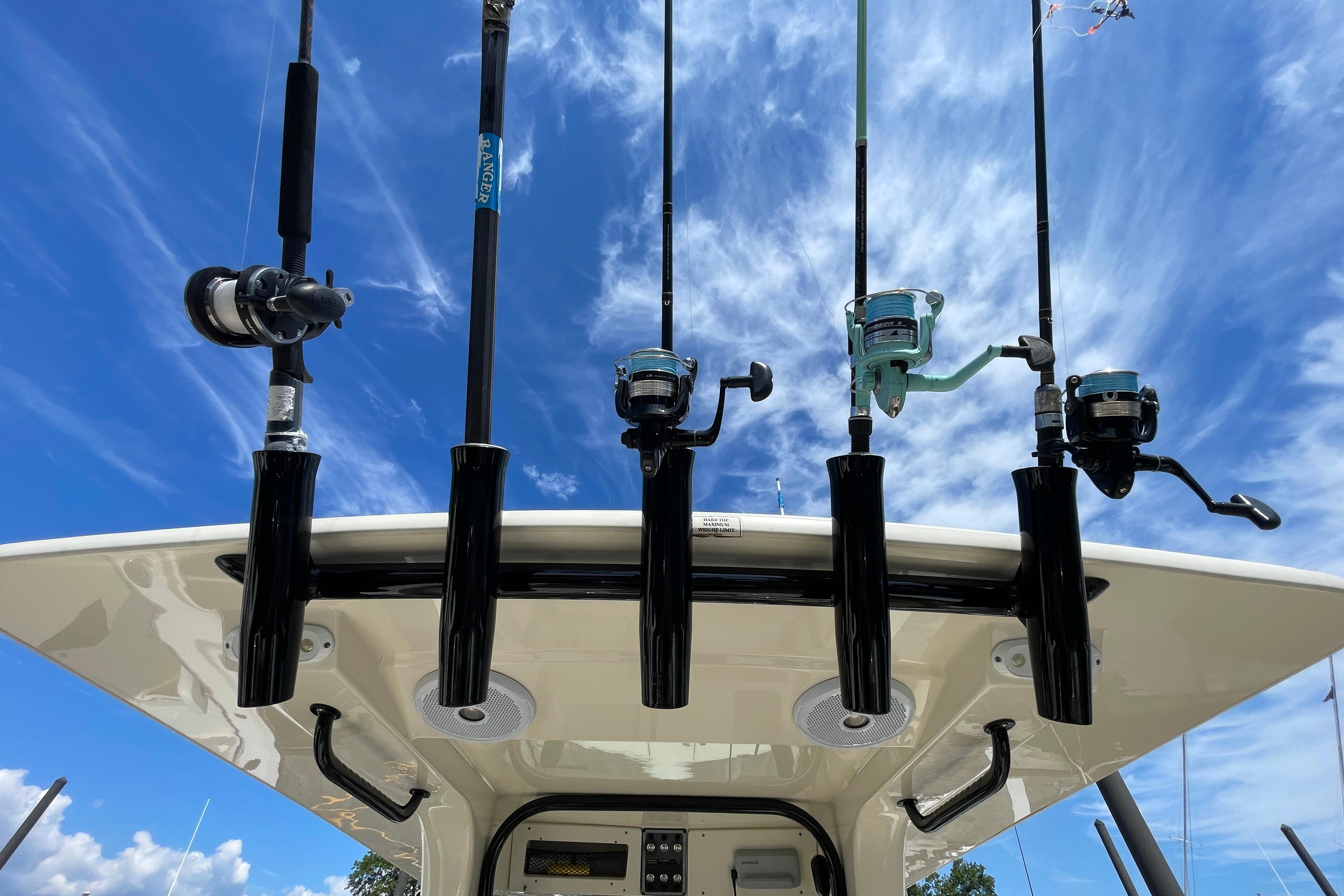 Fishing rods on a 2020 Scout 255 LXF boat against a blue sky.