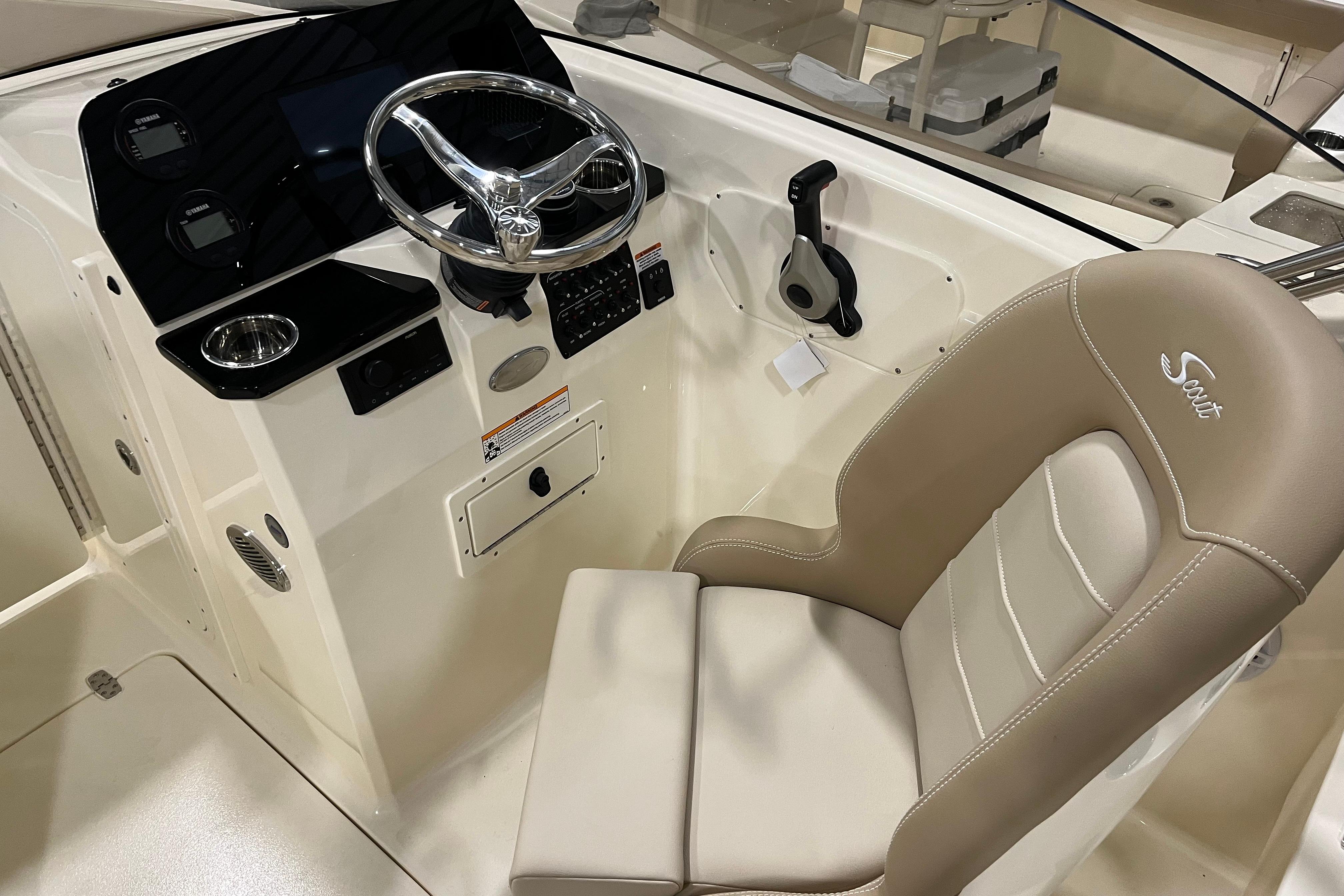 2025 Scout 215 Dorado boat cockpit with steering wheel and beige captain's chair.