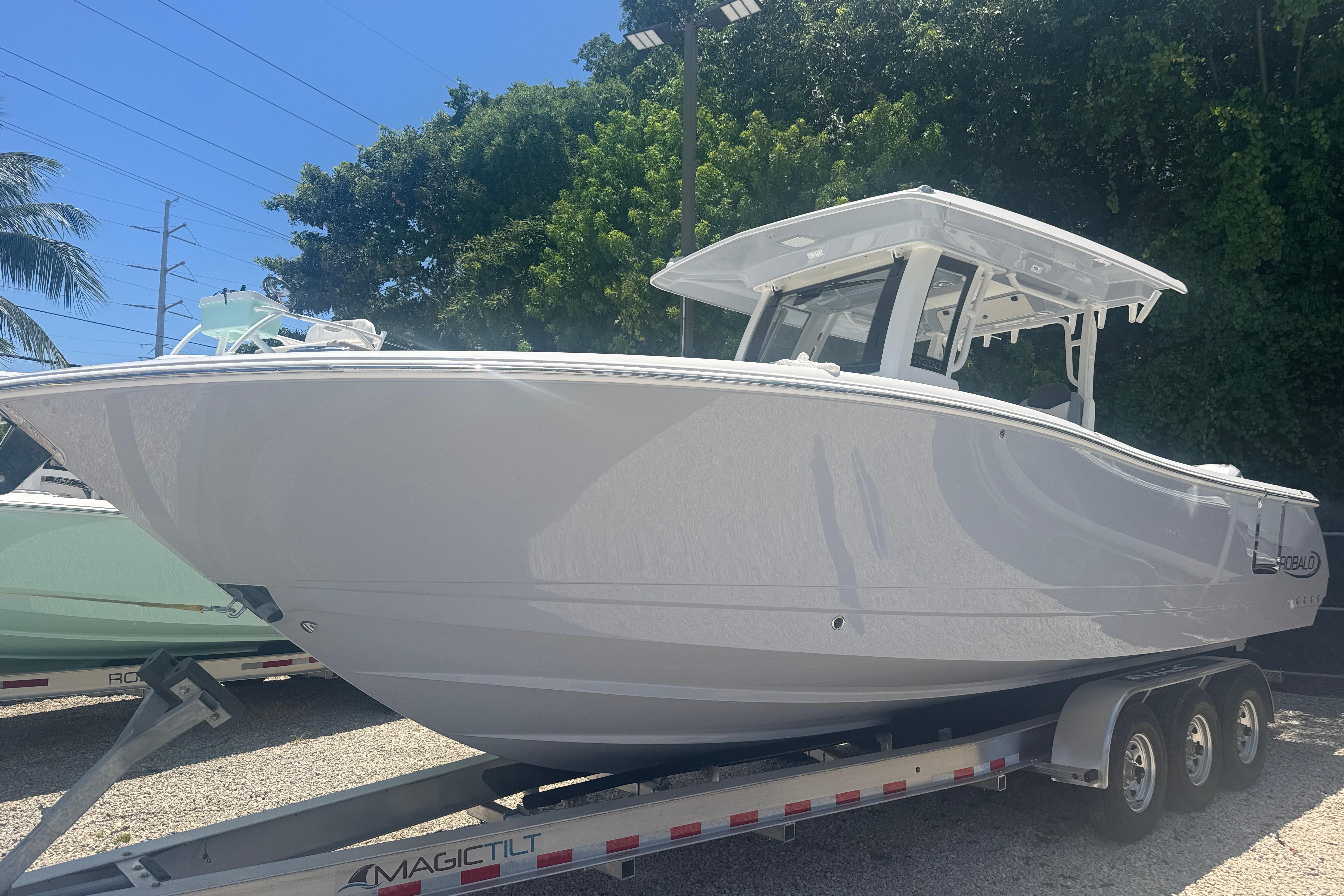 2025 Robalo R300 Center Console boat on trailer, parked outdoors.