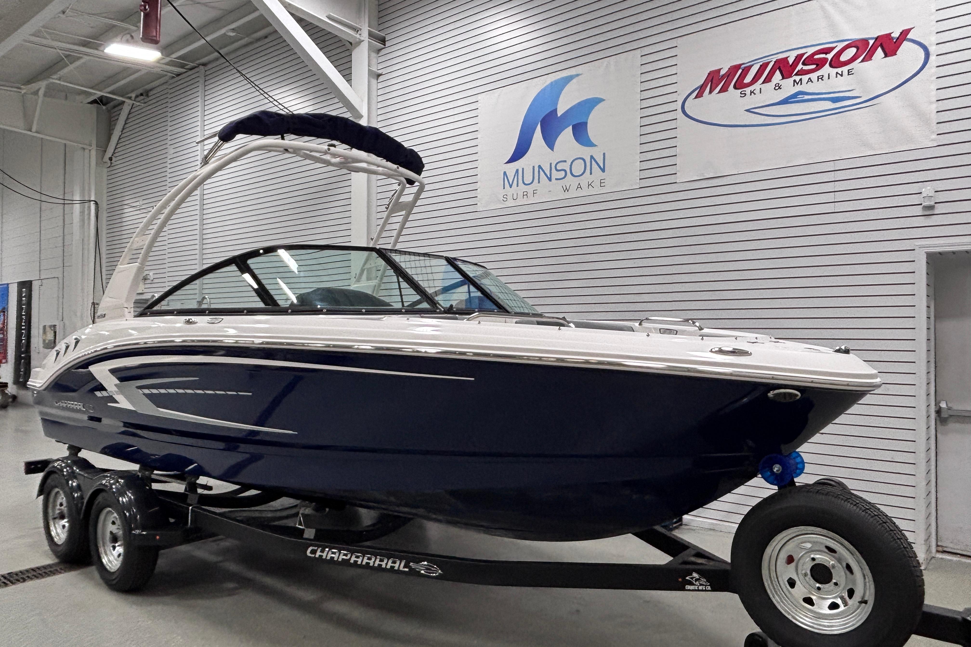 2026 Chaparral 21 SSi boat on trailer in showroom, Munson Ski & Marine signage.