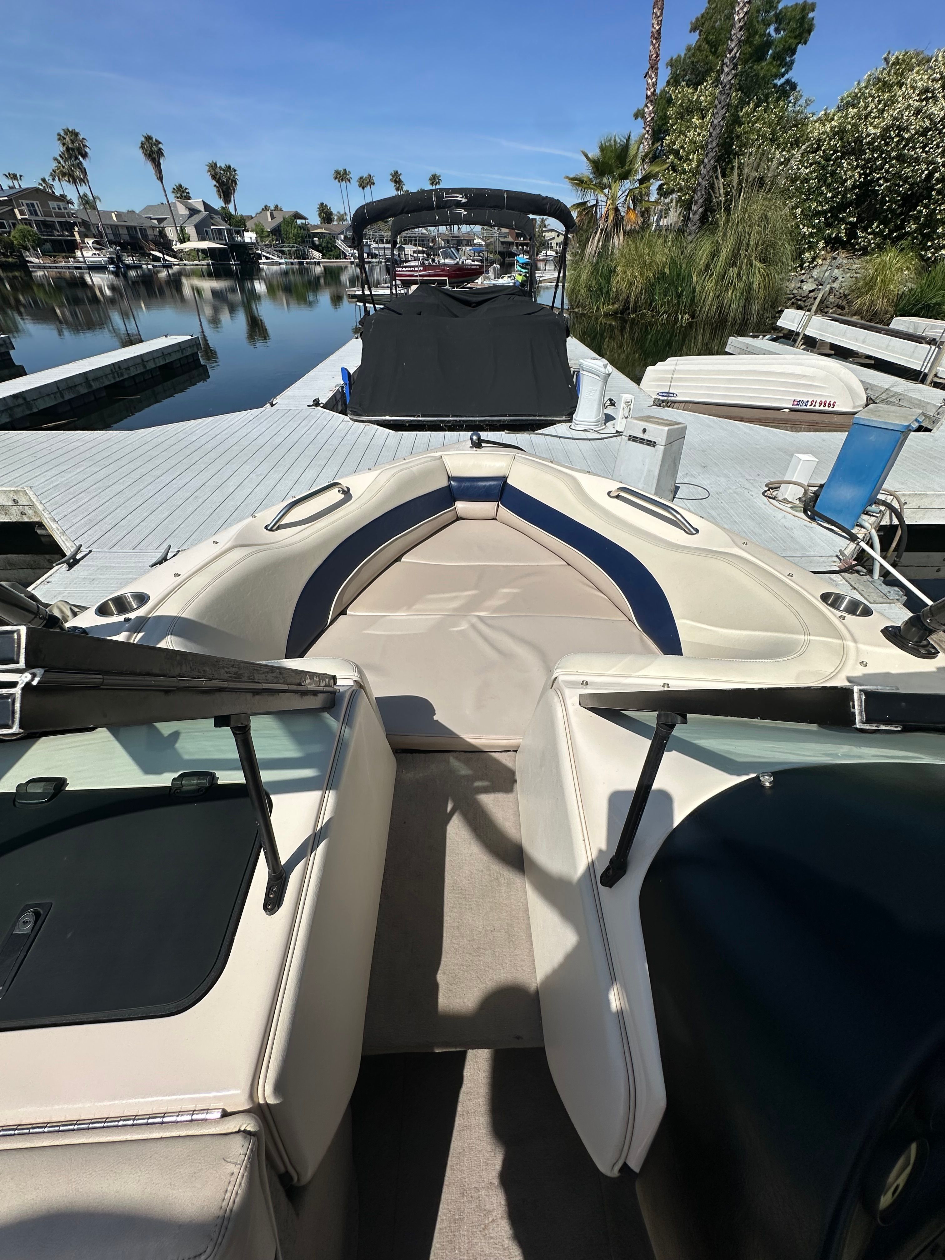 1998 Correct Craft Air Nautique boat at dock, sunny day.