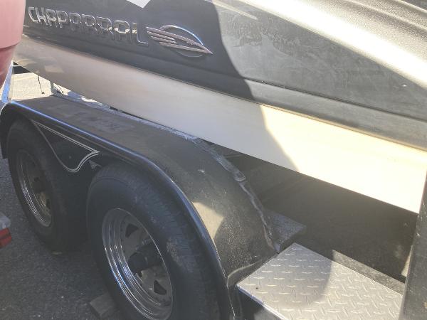 2008 Chaparral 210 SSi boat on trailer, close-up view of side and wheels.
