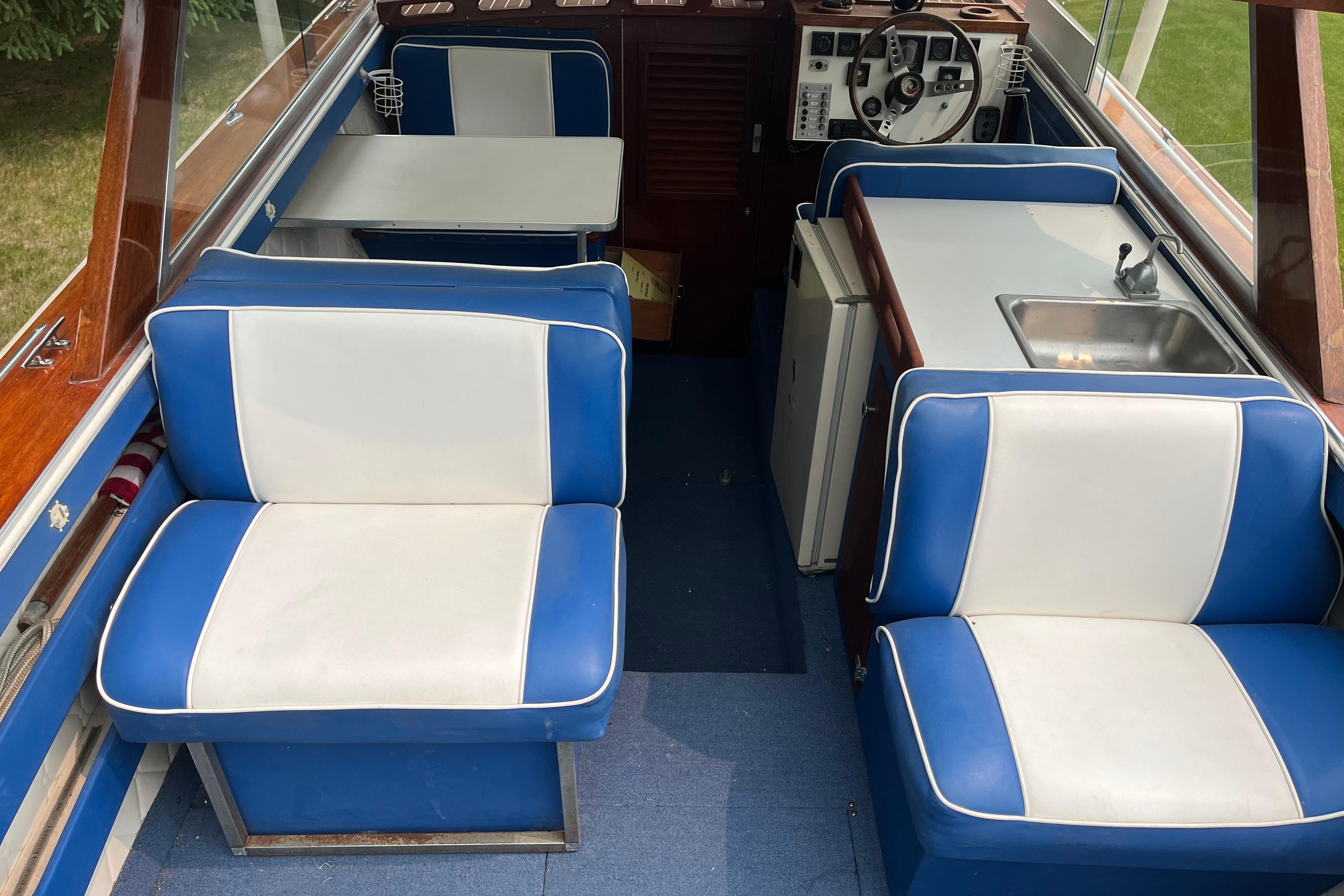 1979 Skiff Craft 24 Flybridge interior with blue and white seating, table, and helm.