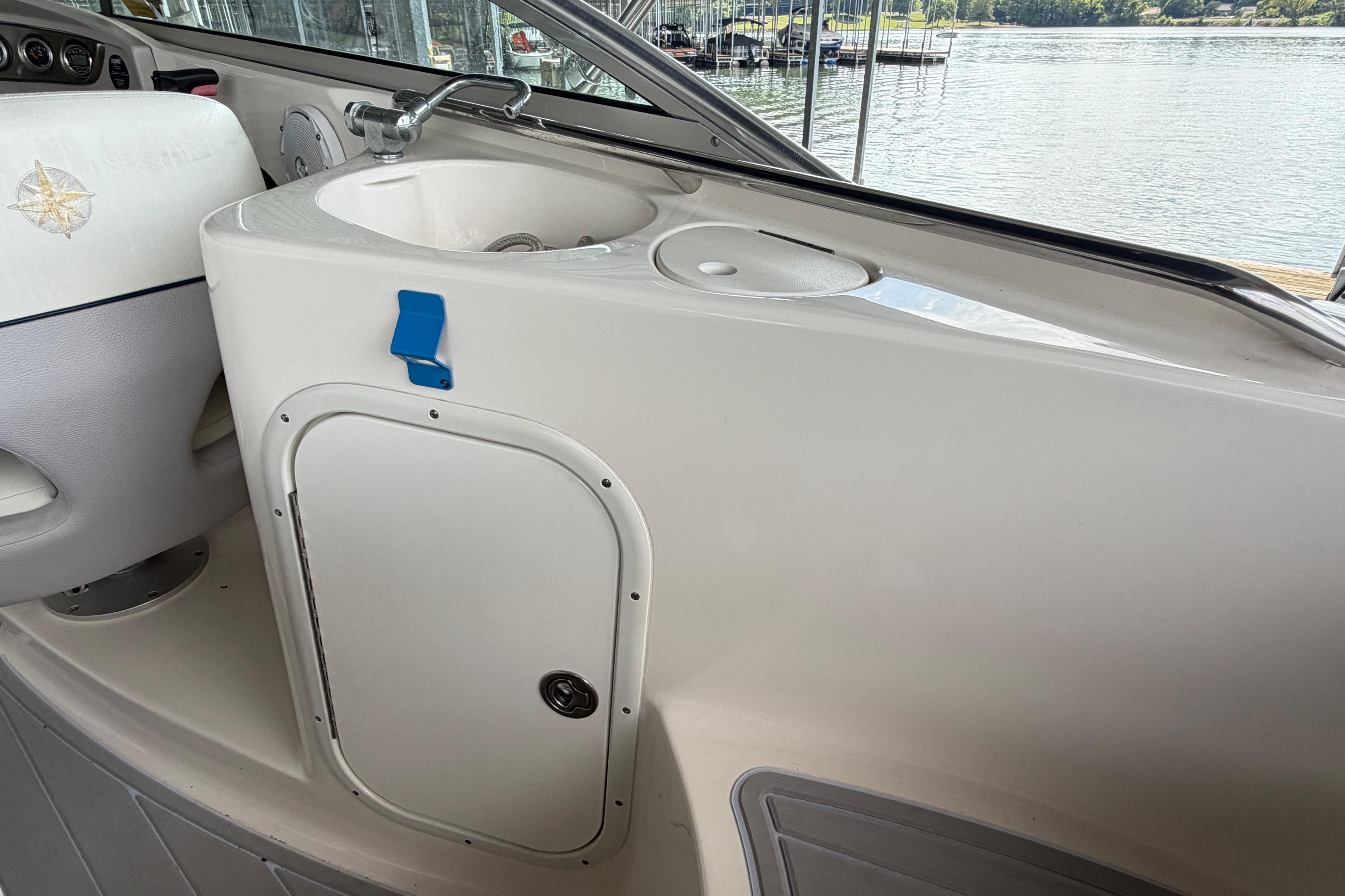 Interior of a 2010 Bryant 255 boat featuring a sink and storage compartment.