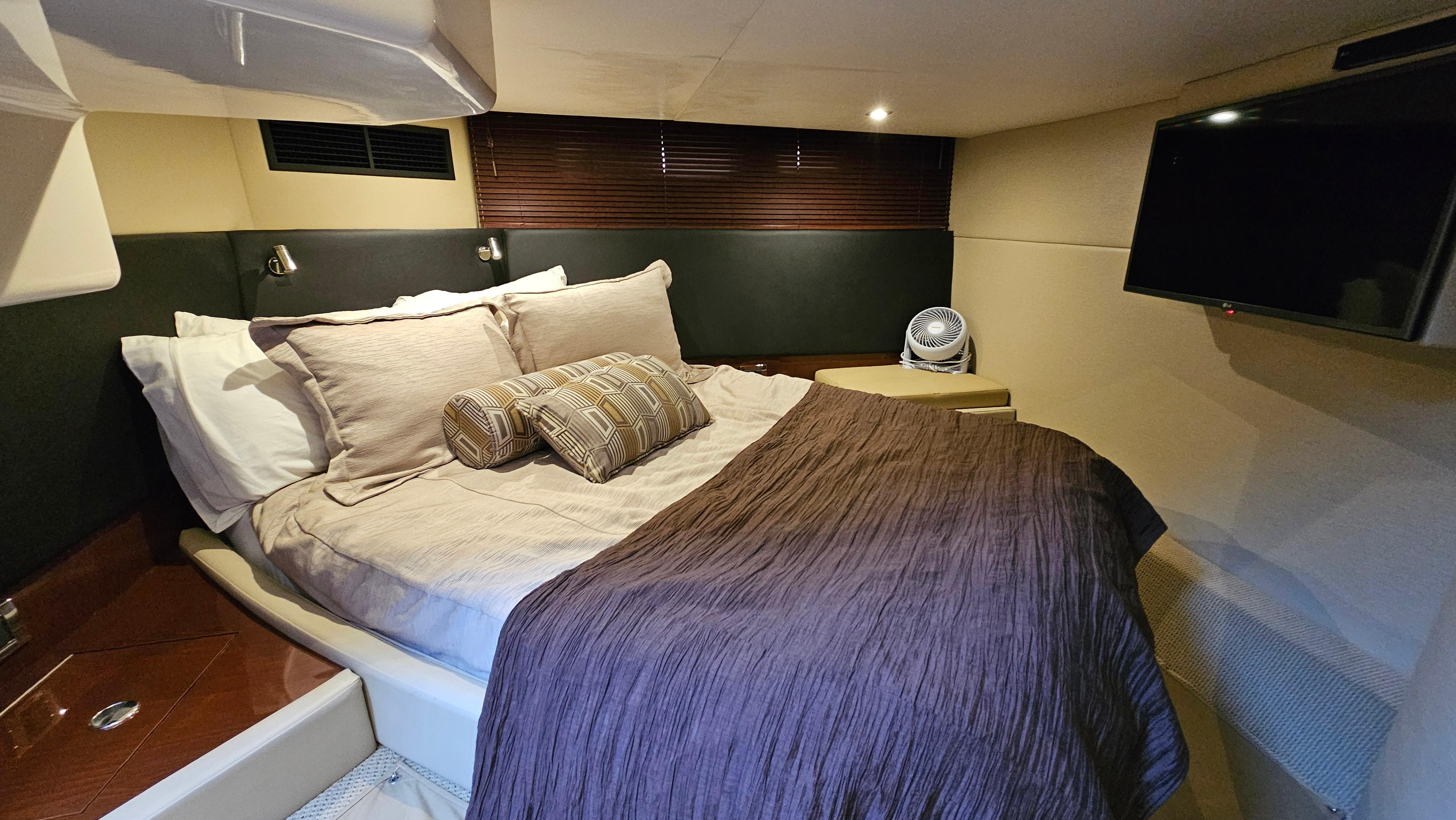 Luxurious cabin interior of 2016 Sea Ray 470 Sundancer with cozy bed and modern decor.