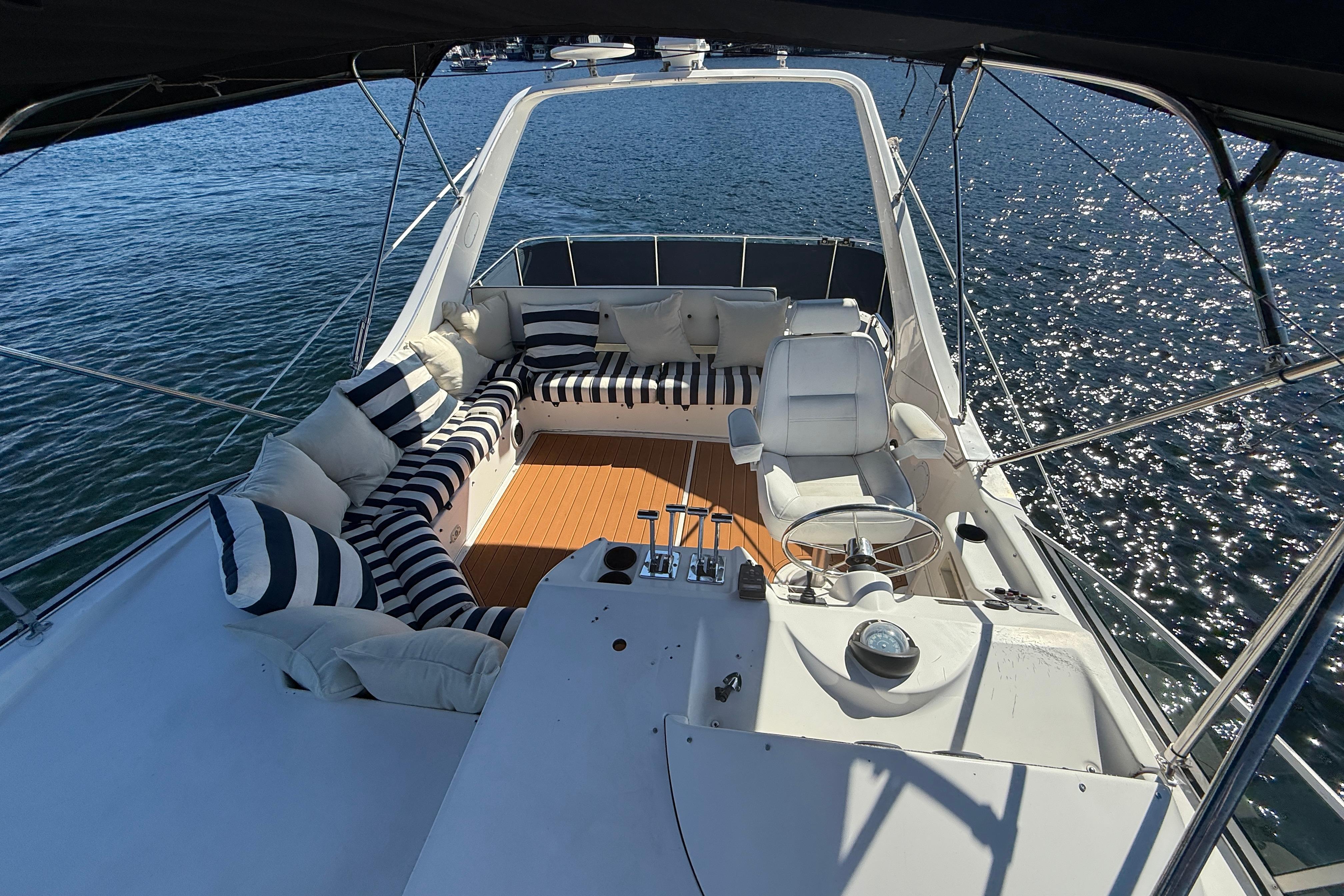 1997 Bayliner 3988 Command Bridge Motoryacht with striped seating on sunny water.