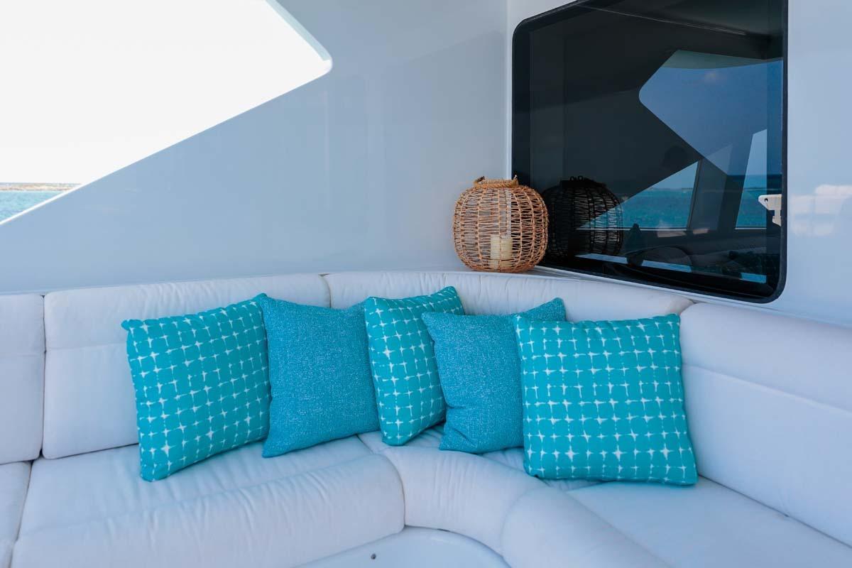 Luxurious Westship Skylounge 2001 yacht interior with turquoise cushions and wicker decor.