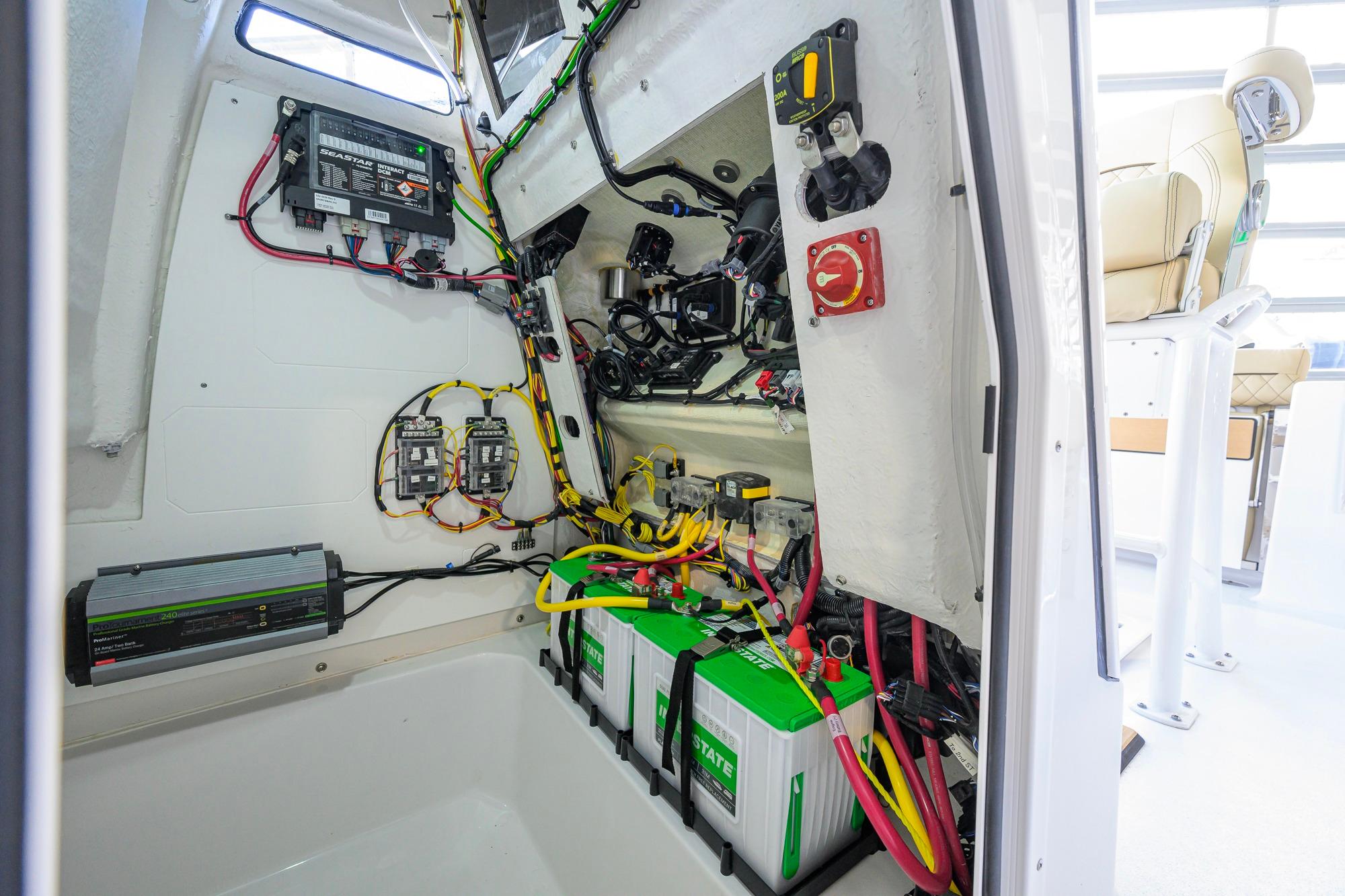 Interior view of 2026 Sportsman Open 212 Center Console boat's electrical system and battery setup.