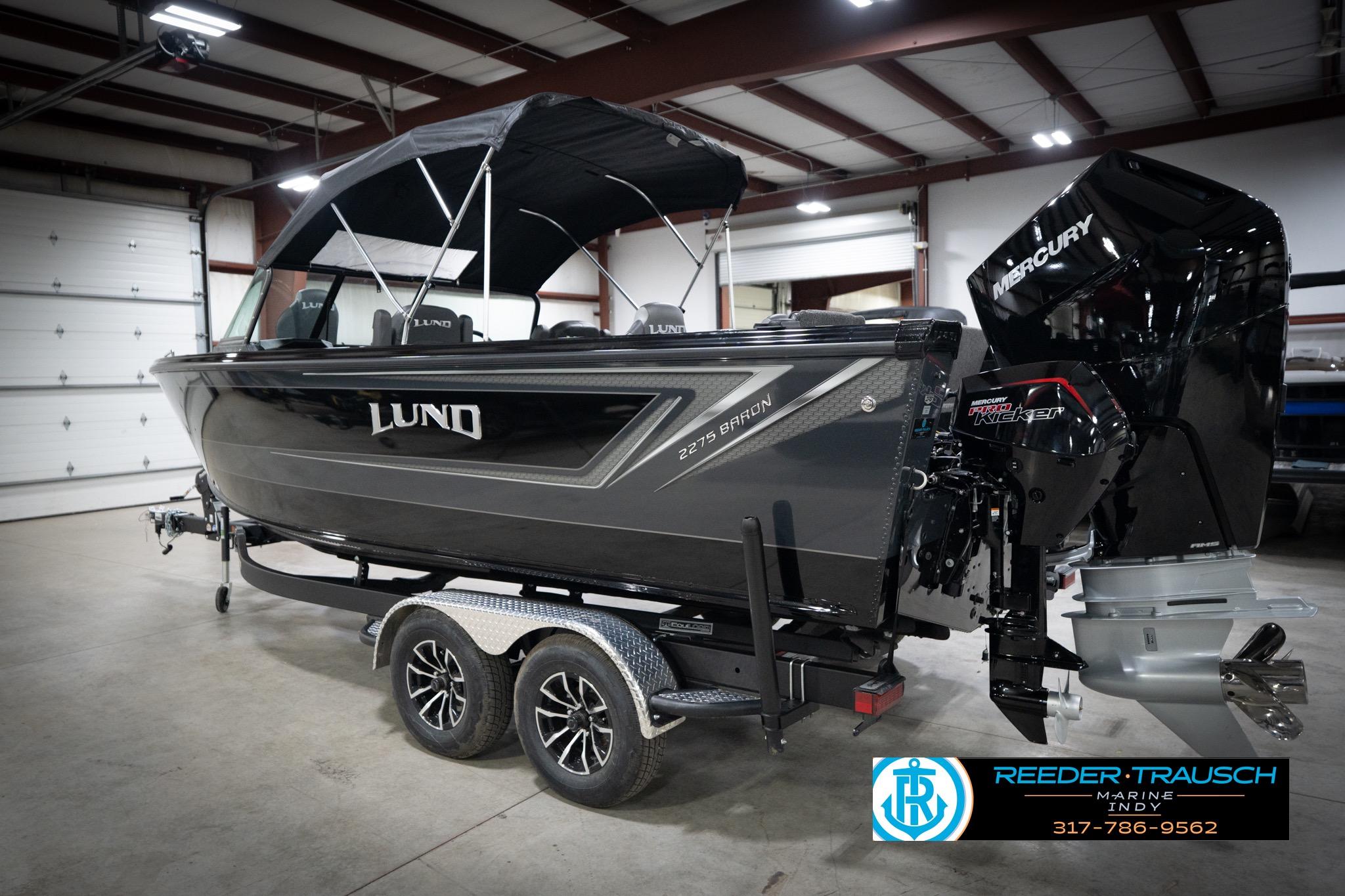 2026 Lund 2275 Baron boat in showroom with Mercury engine, on trailer.