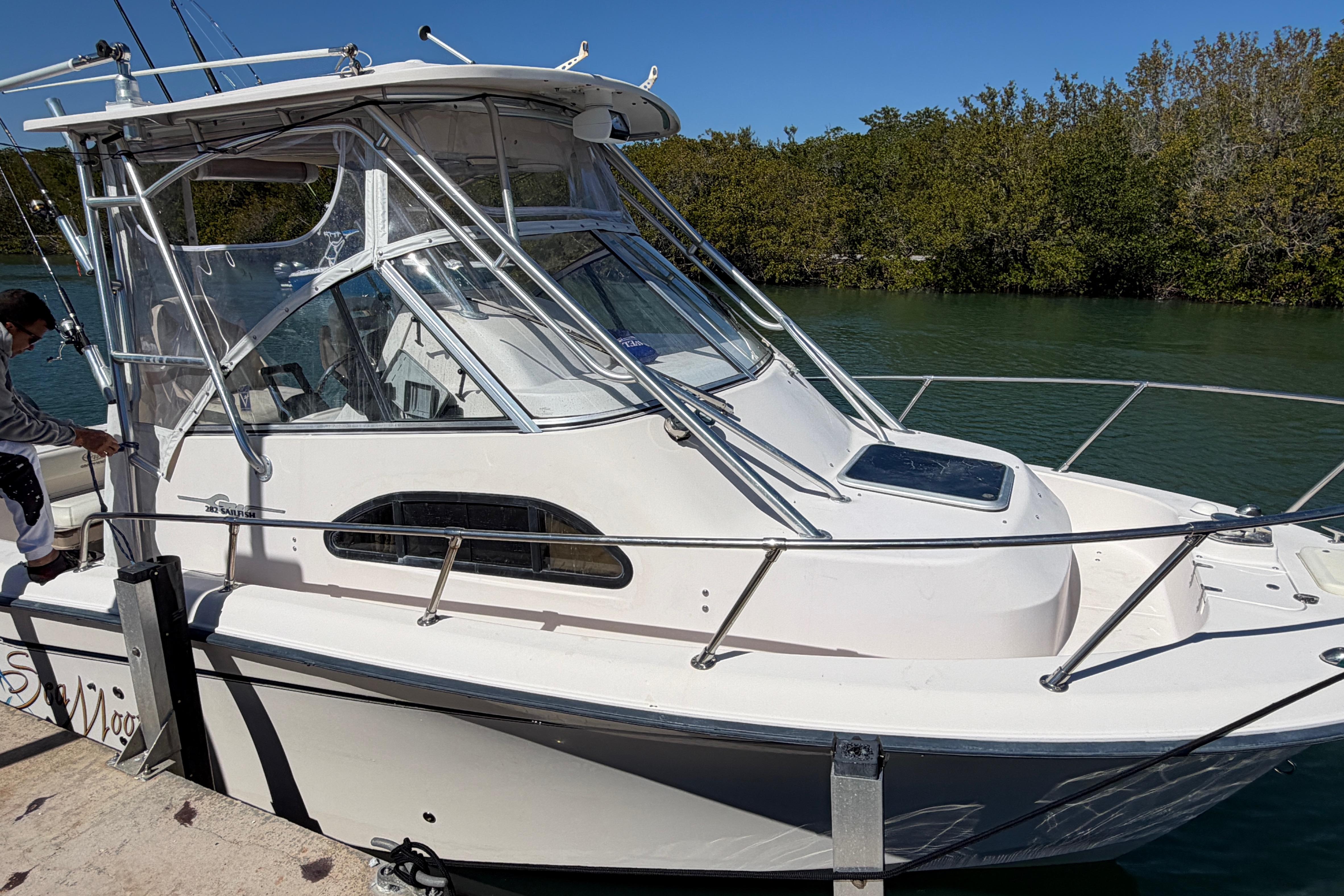 2006 Grady-White Sailfish 282 boat docked by lush greenery.
