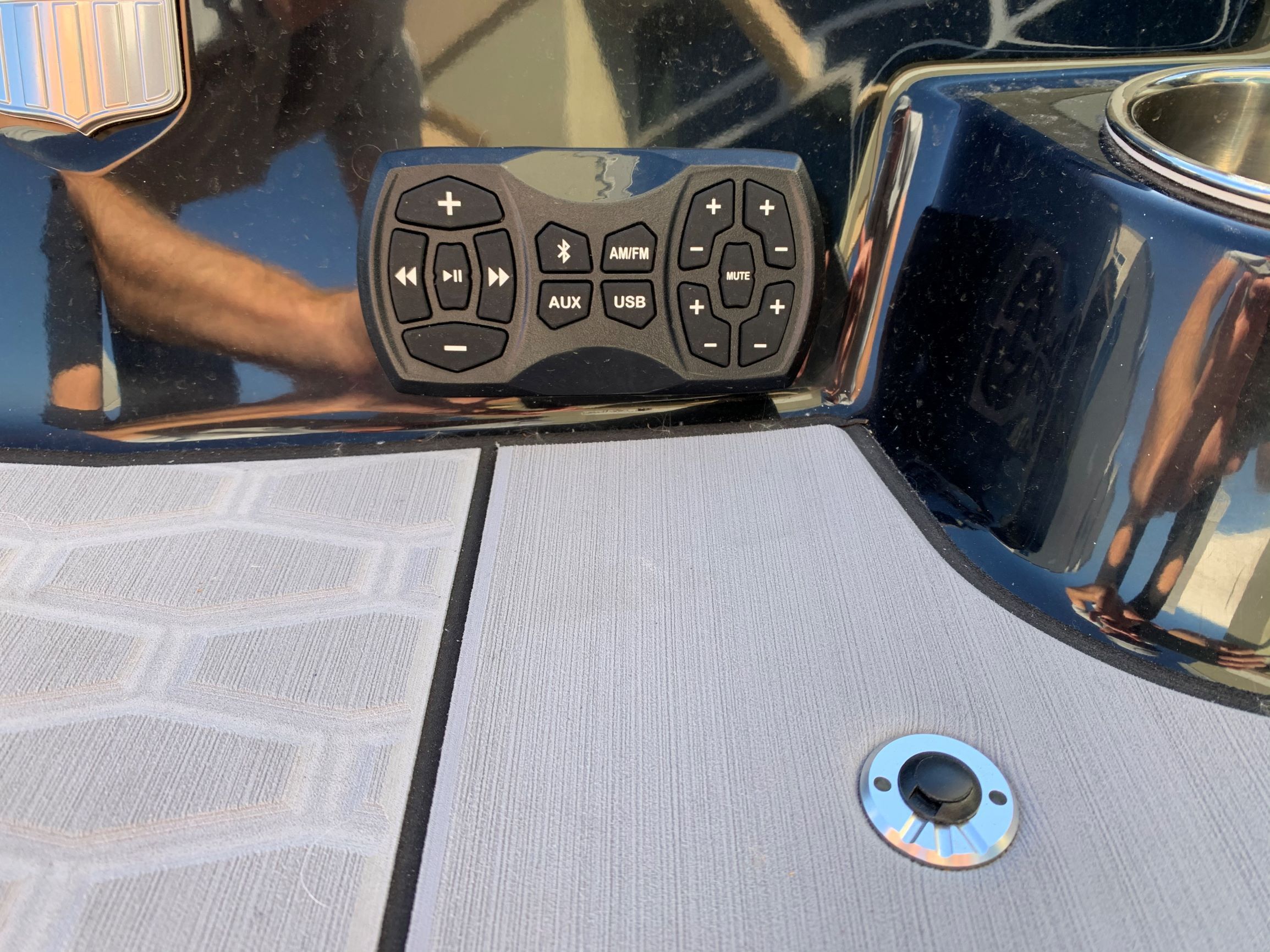 Close-up of a control panel on a boat with various controls and a cup holder.