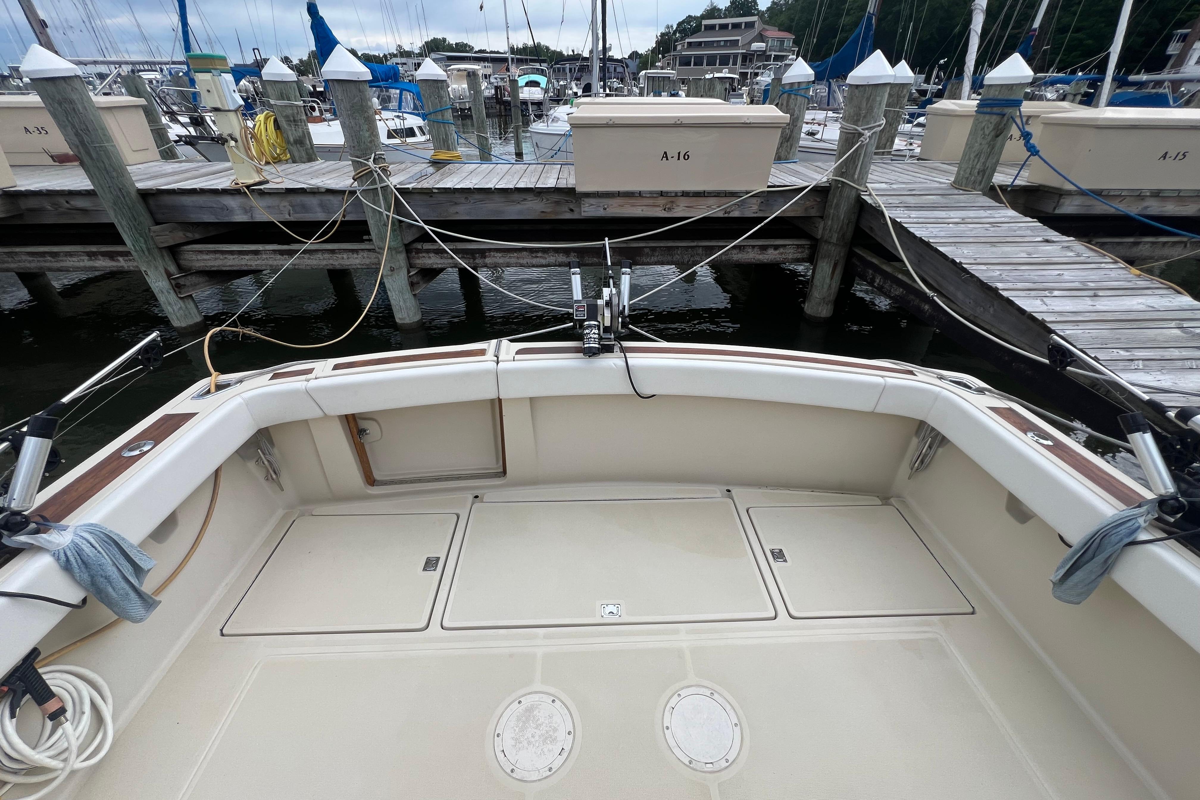 1985 Tiara 36 OPEN boat docked at marina, showcasing spacious deck and fishing equipment.