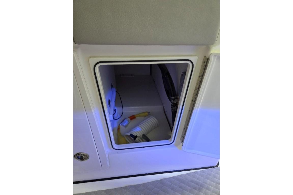 2023 Pursuit S 328 Sport boat storage compartment with interior lighting and equipment.