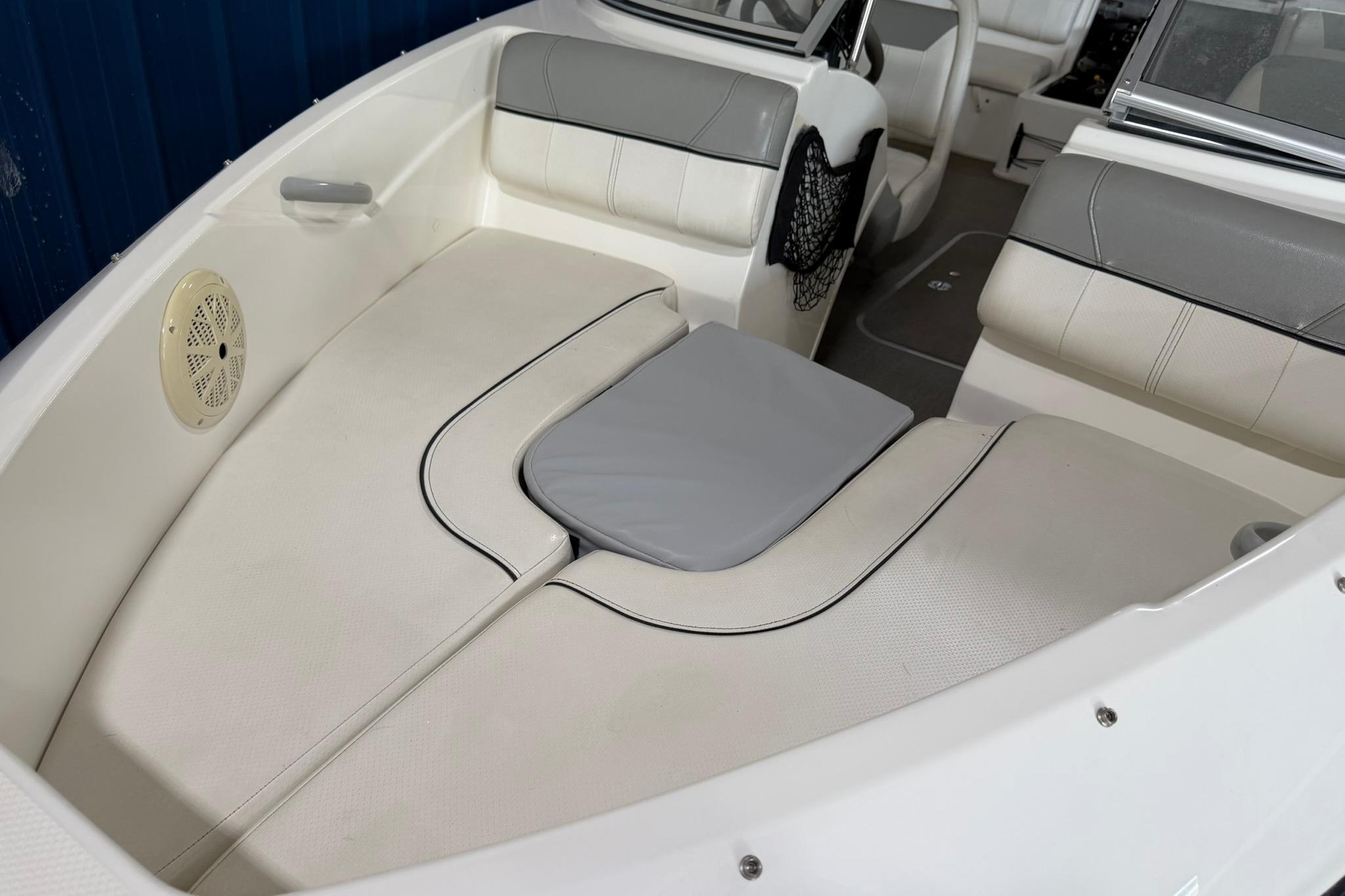 2012 Bayliner 175 Bowrider interior with white cushioned seating and speaker detail.