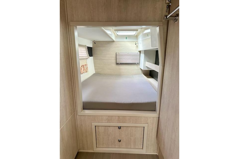 Interior cabin of a 2017 Leopard 40 catamaran with a cozy bed and storage.