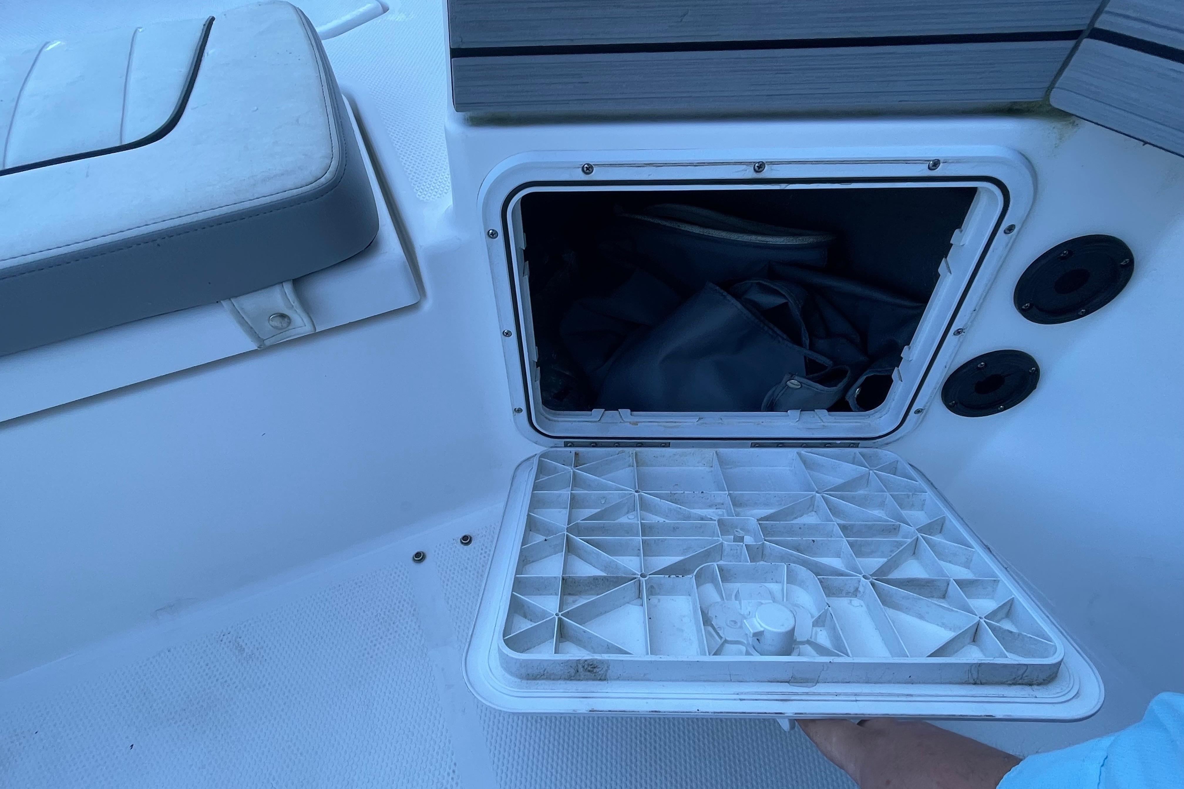 Open storage compartment on 2021 Yamaha Boats 195 FSH Sport, showing interior space.