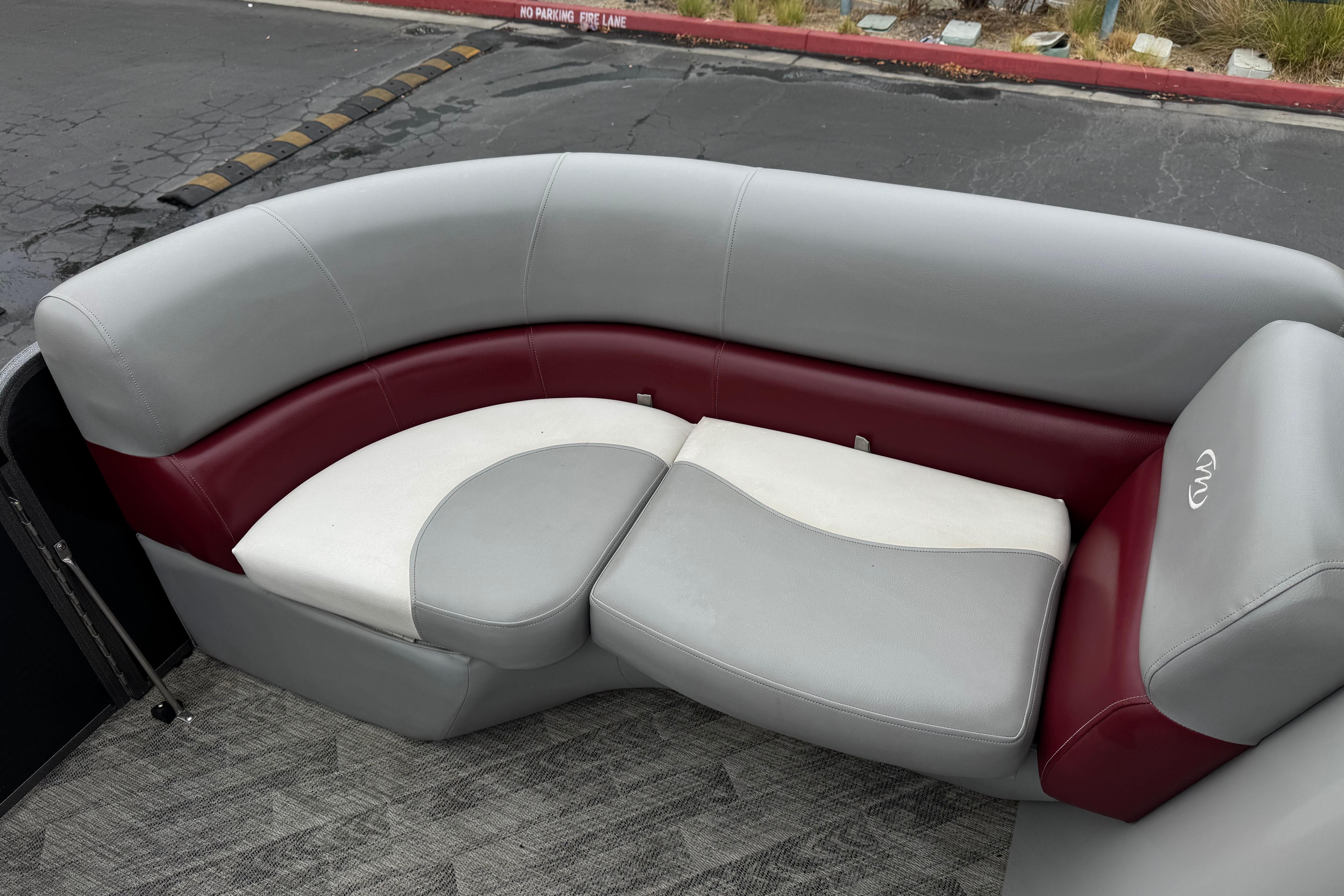 2020 Manitou 18 Aurora LE boat seating with gray and maroon upholstery, outdoor setting.