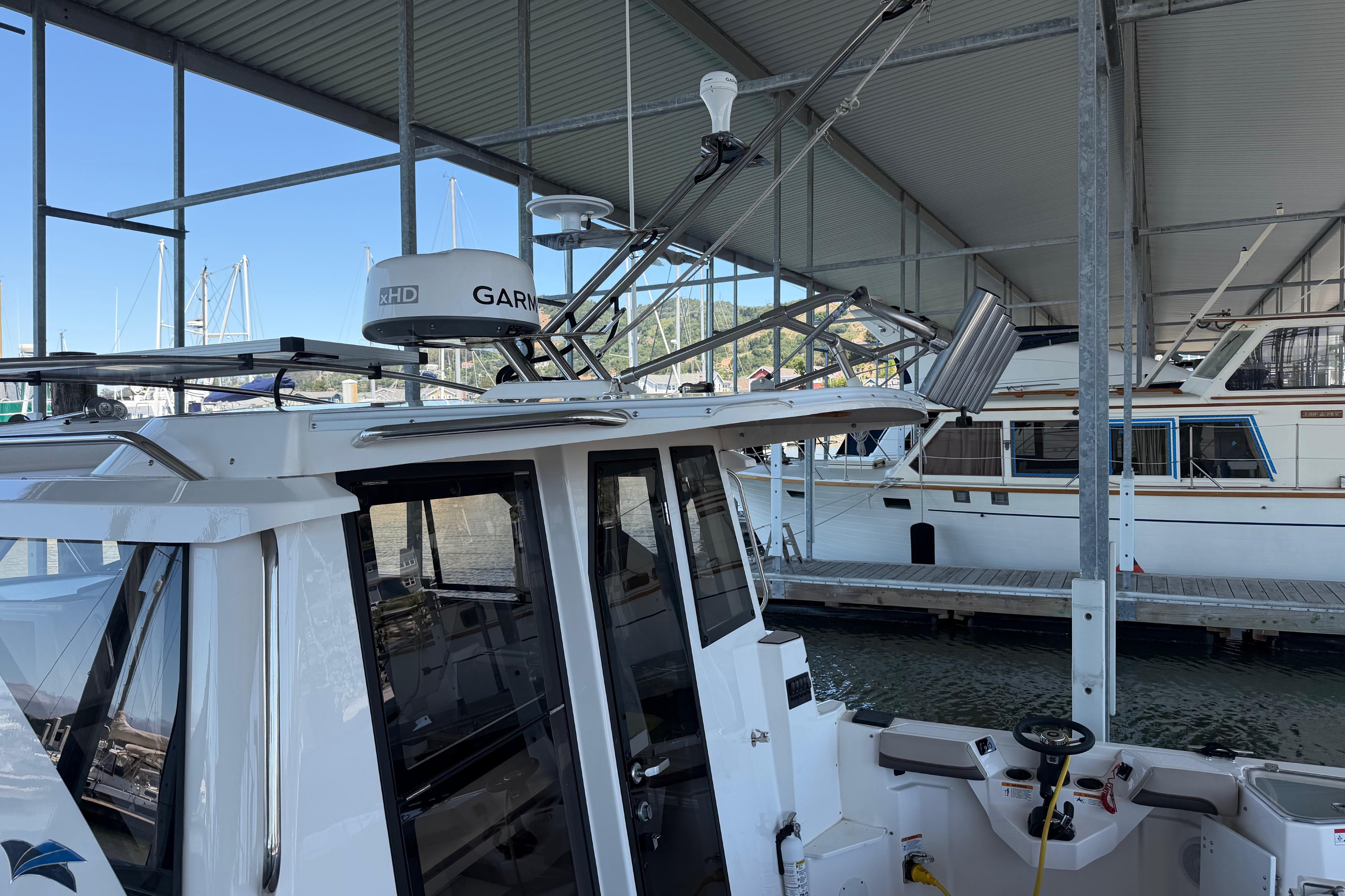 2023 Cutwater C-288 Coupe docked under a covered marina with Garmin radar.