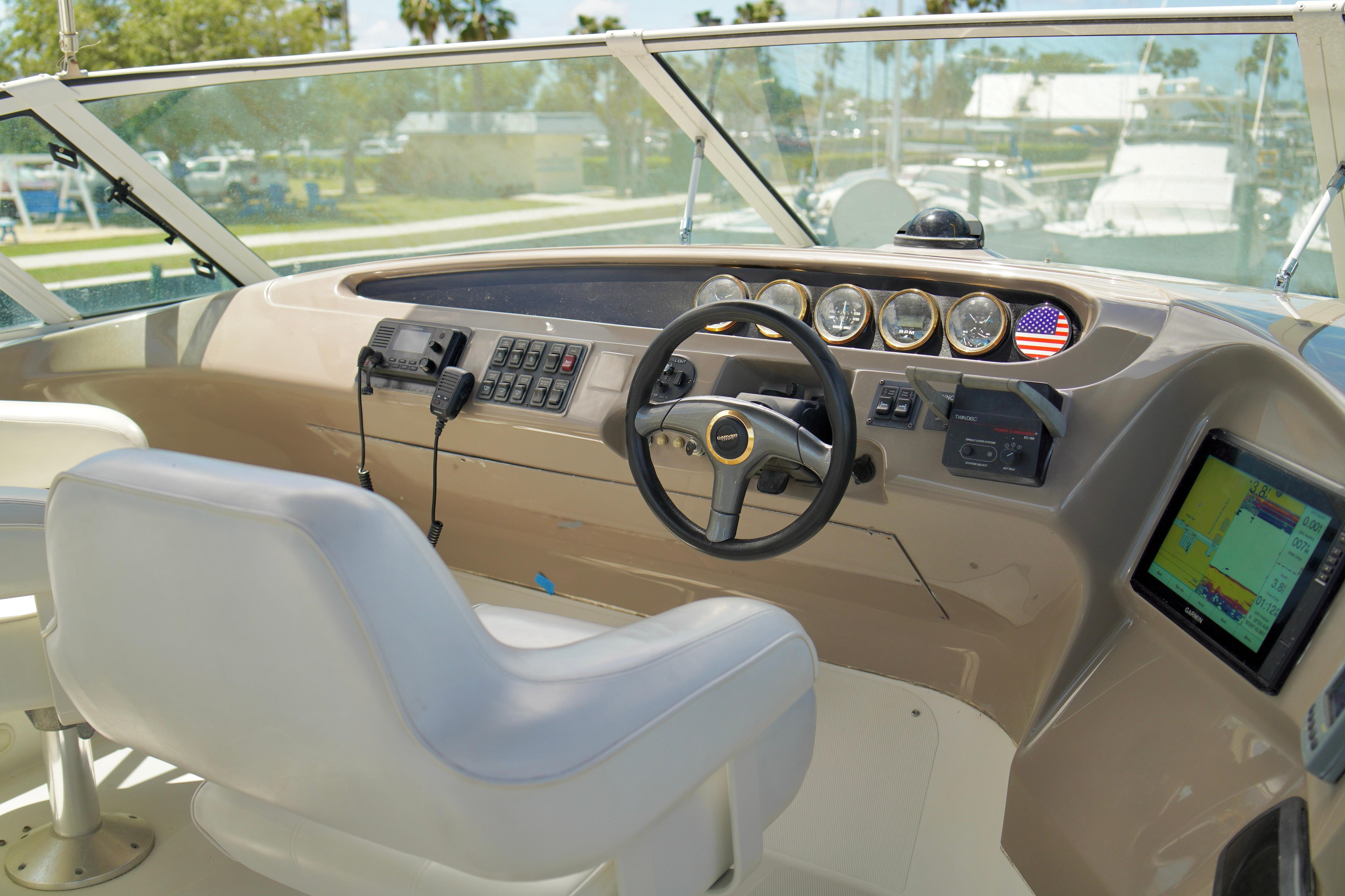 1999 Carver 450 Voyager Pilothouse helm with steering wheel, gauges, and navigation equipment.