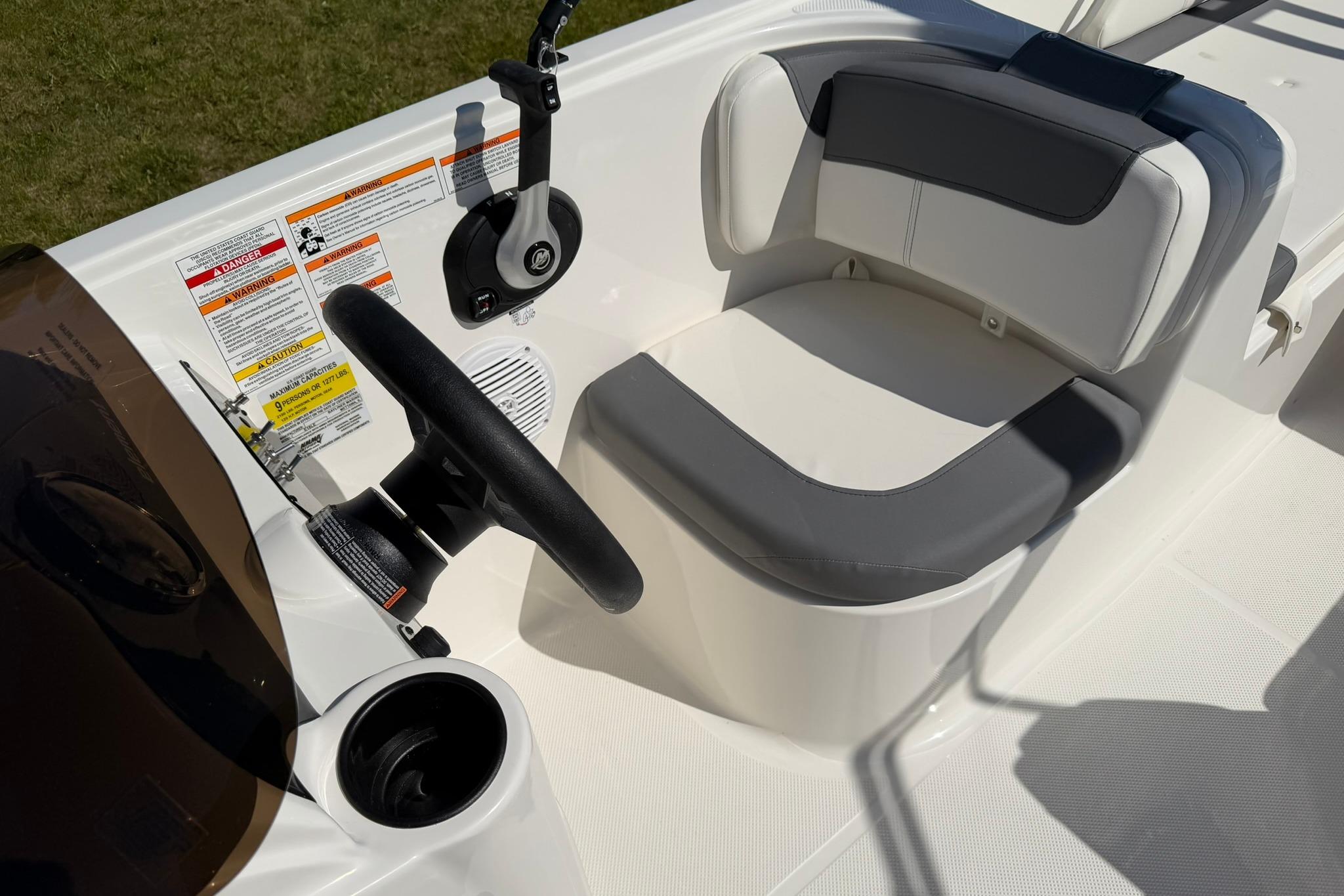 2026 Bayliner Element E18 boat cockpit with steering wheel and cushioned seating.